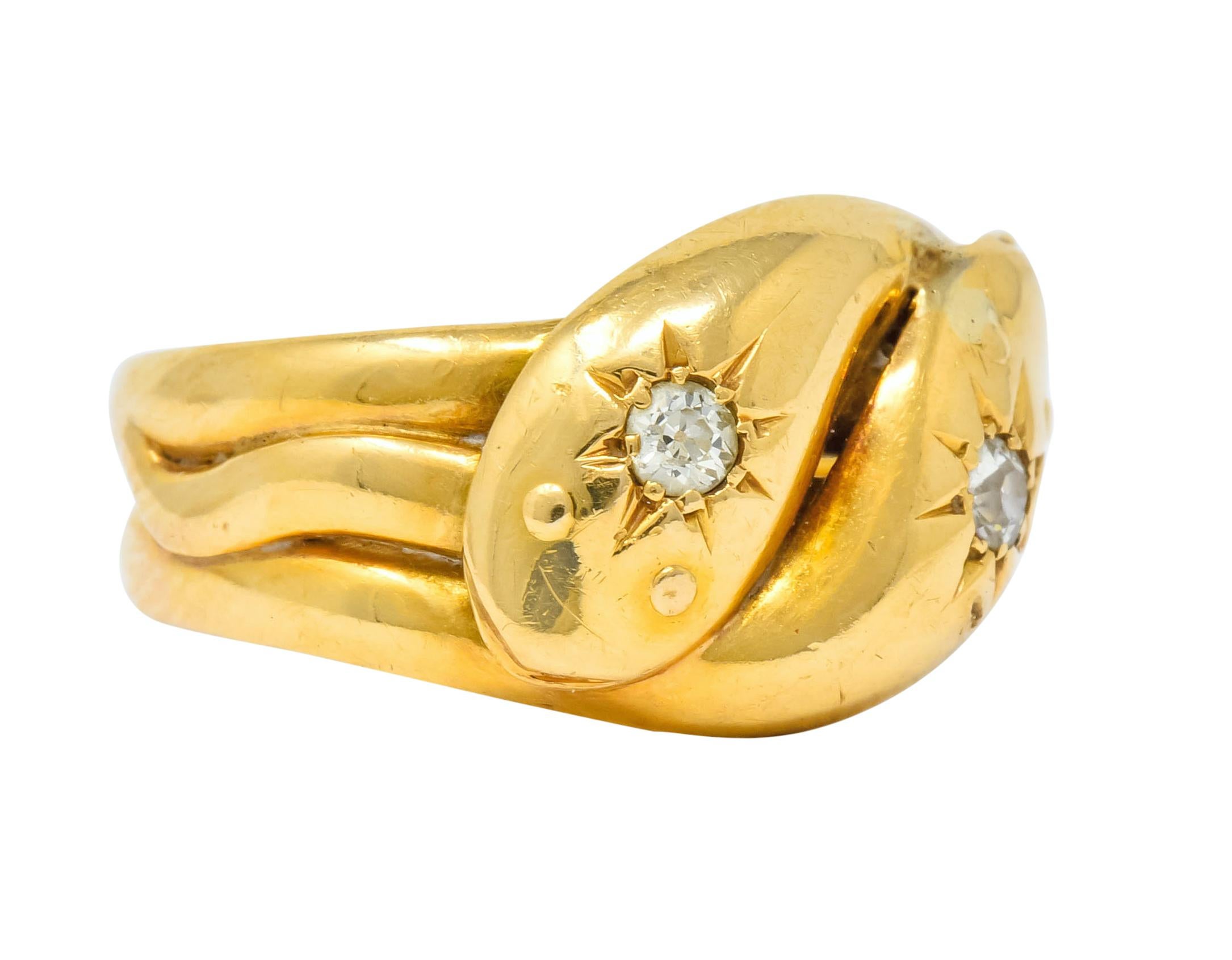 Band style ring designed as two coiled snakes with bodies forming a wide band tapering from three to two sections

Each snake head featuring a graver set old mine cut diamond, eye clean and white

With British hallmarks for 18 karat gold

Ring Size: