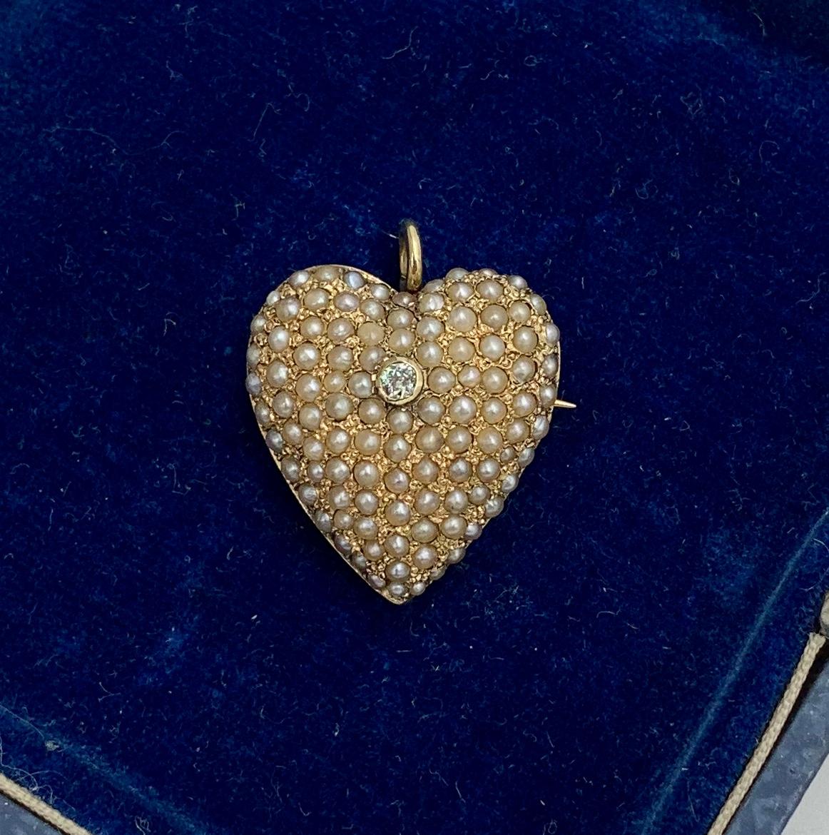 An Antique Victorian Heart Pendant set throughout with lovely Seed Pearls.  In the center is a sparkling Old Mine Cut Diamond.  The diamond and pearls are set in a wonderful 14 Karat Gold Heart.  The Heart has a swivel bale which can be flipped down