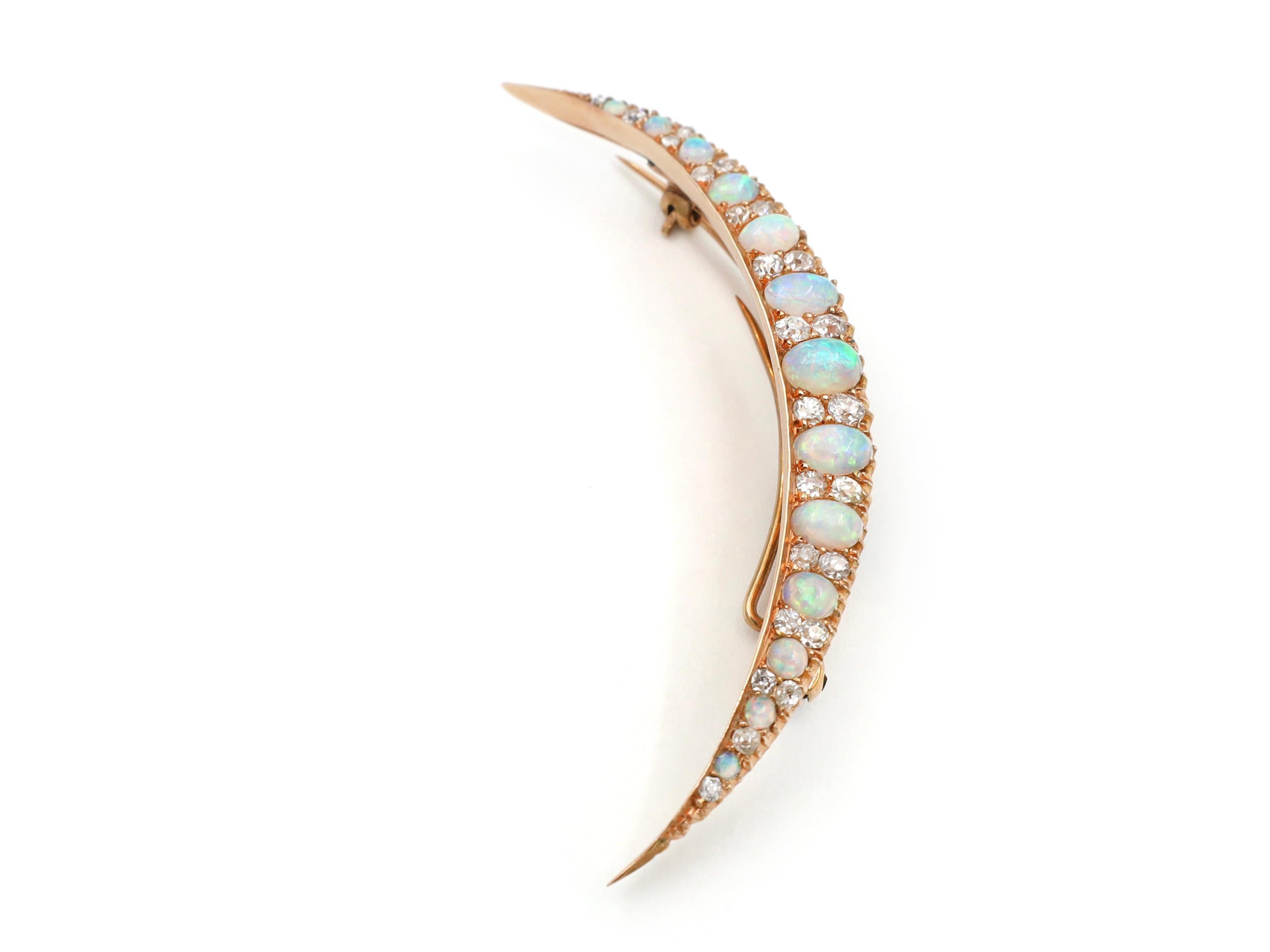 Victorian opal and diamond crescent moon brooch in 18kt yellow gold. Set with thirteen graduating oval and round cabochon precious opals in grain settings, each alternating with diamond set intervals set with round old cut diamonds in grain