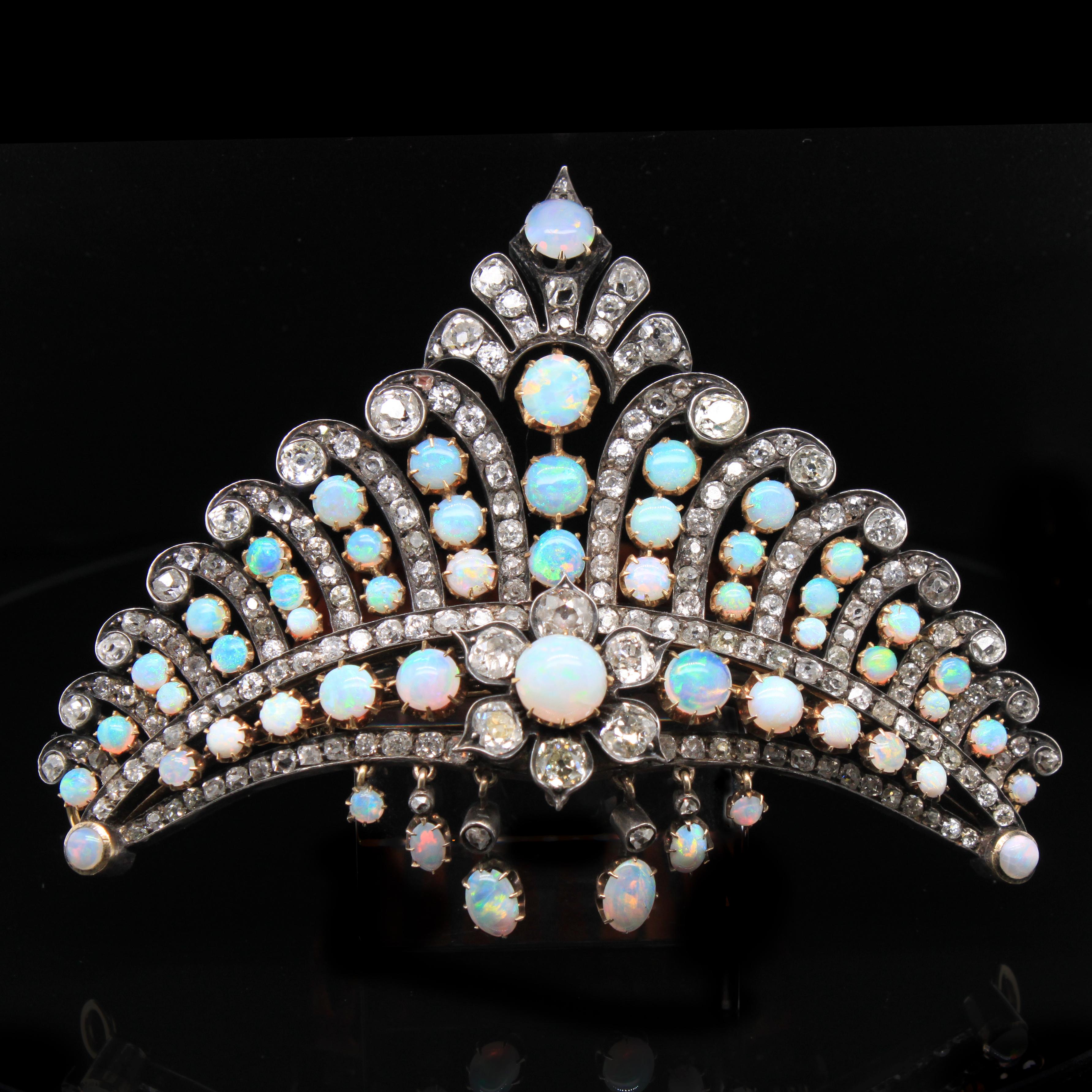 Victorian Opal and Diamond Crown Haircomb Necklace, ca. 1880s

A very unusual and stunning Victorian crown, set with fiery opal cabochons and old-mine cut diamonds, from the 1880s.
The setting alternates with rows of fine opal cabochons that show a