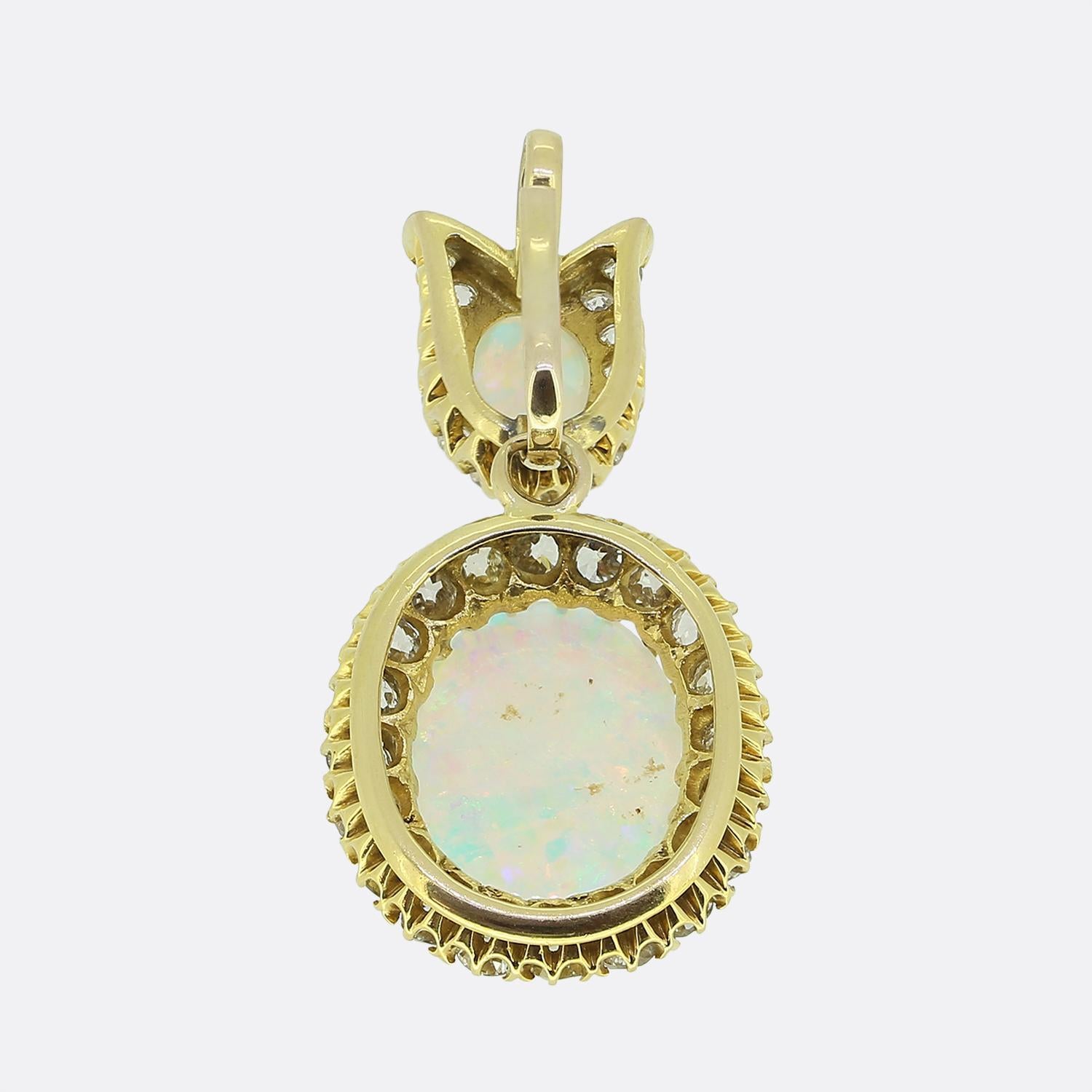 Nous avons ici un magnifique pendentif en forme de goutte d'eau datant de l'époque victorienne. Réalisé en or jaune 18 ct, le design présente un duo d'opales blanches opulentes scintillant avec des éclats intenses de bleus et de verts, ainsi que des