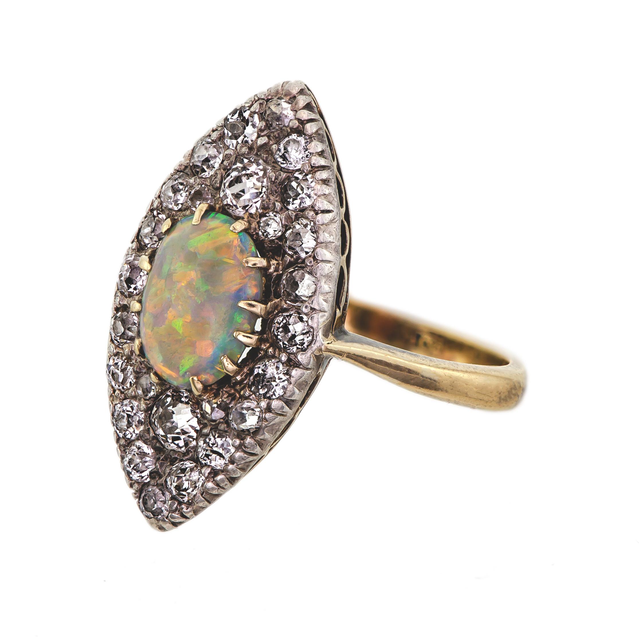 Beautiful Victorian Circa 1890 silver topped yellow gold opal and old mine cut diamond ring navette shaped set with approximately .65 cts total weight plus of chunky old mine cut diamonds surrounding one oval cabochon cut crystal opal.  Beautiful