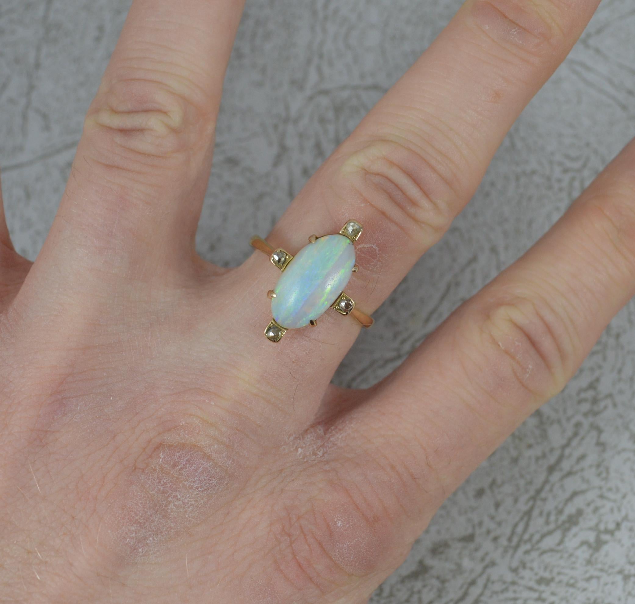 A fine opal and diamond ring, circa 1880.
Solid 18 carat yellow gold example.
Set with one oval shaped opal in four claw setting. 8mm x 14mm approx.
Surrounding are four rose cut diamonds in four square heads. 12.8mm x 19.2mm. Protruding 6.4mm off