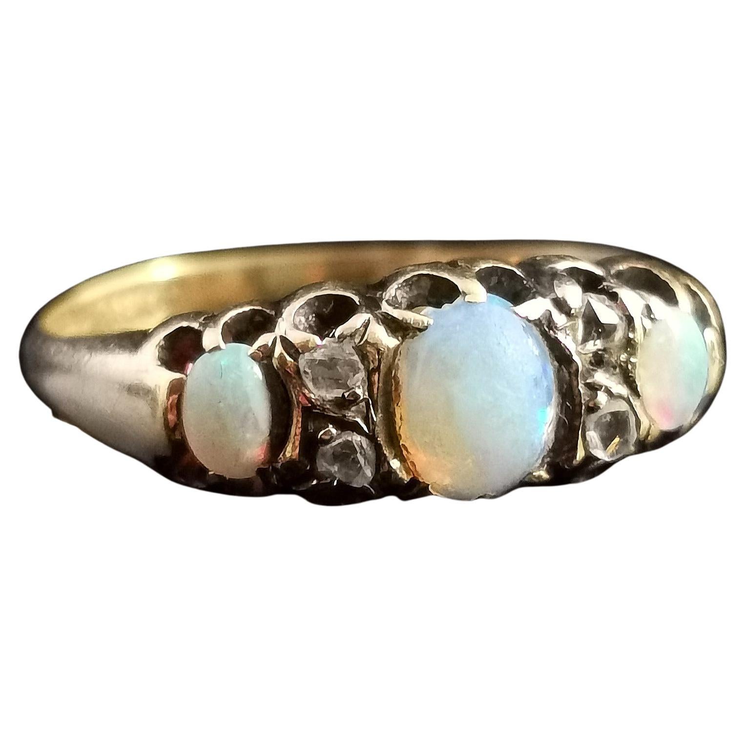 Ein attraktiver antiker, spätviktorianischer Ring mit Opal und Diamant im Rosenschliff.

Ein reichhaltiges Band aus 18 Karat Gelbgold mit einer Fassung im Stil eines Schiffskopfes.

Die Vorderseite ist mit drei wunderschönen Opal-Cabochons besetzt,