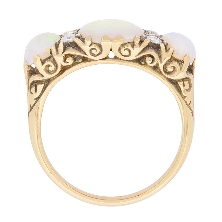 This enchanting late Victorian era ring is set in 18 carat yellow gold with a pleasing combination of antique opals and rose cut diamonds.

Graduating from the ring’s centre, three lovely pastel-hued, oval-shaped opals are set within decorative