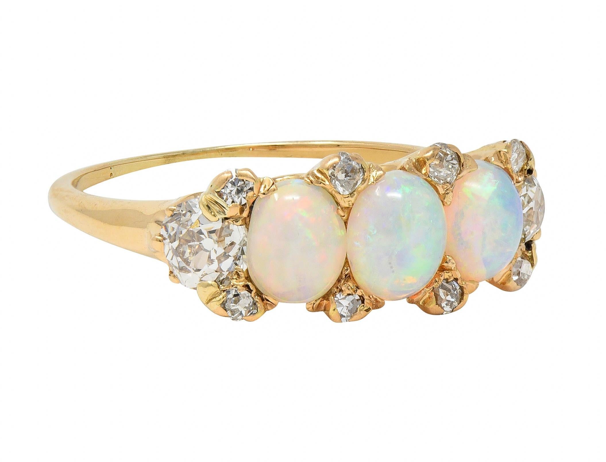 Featuring three oval-shaped opal cabochons ranging in size from 3.5 x 4.5 mm to 4.0 x 5.0 mm 
White body color with spectral play-of-color - prong set east to west
Accented by old European cut diamonds bead set in between
With old mine cut diamonds