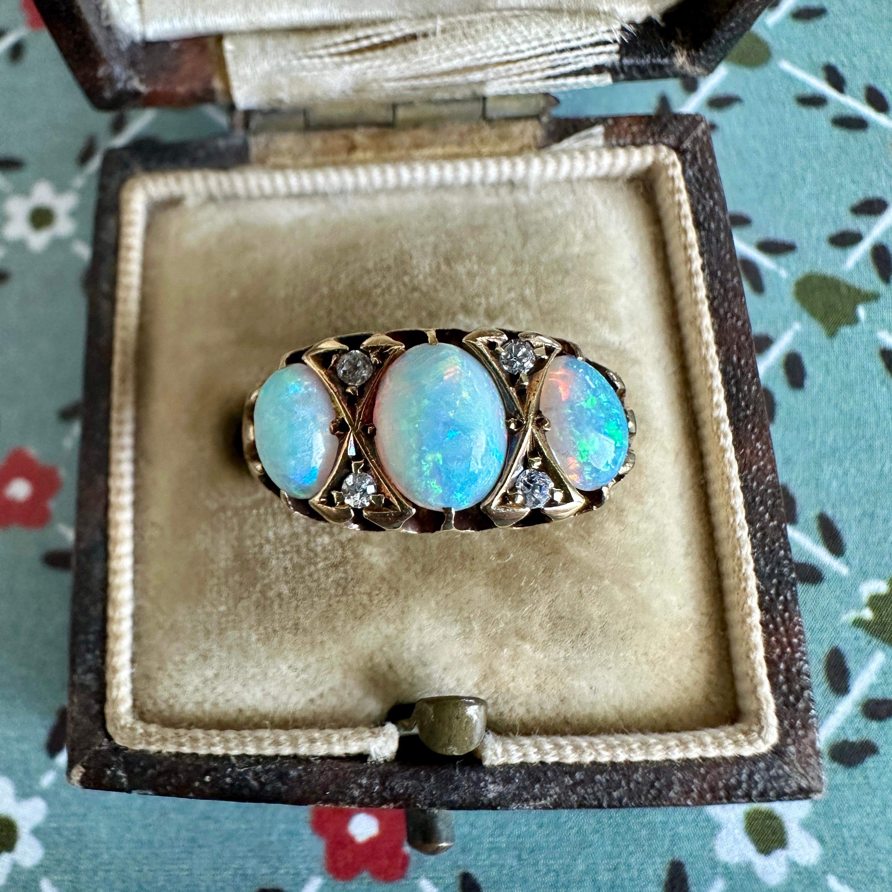 Details:
Looking for a Victorian opal ring? This fabulous ring has three beautiful, full spectrum opals with blue, green, orange, pinks. The stones are prong set, and are in great shape, with no scratches, scuffs or chips. The old hand cut diamonds