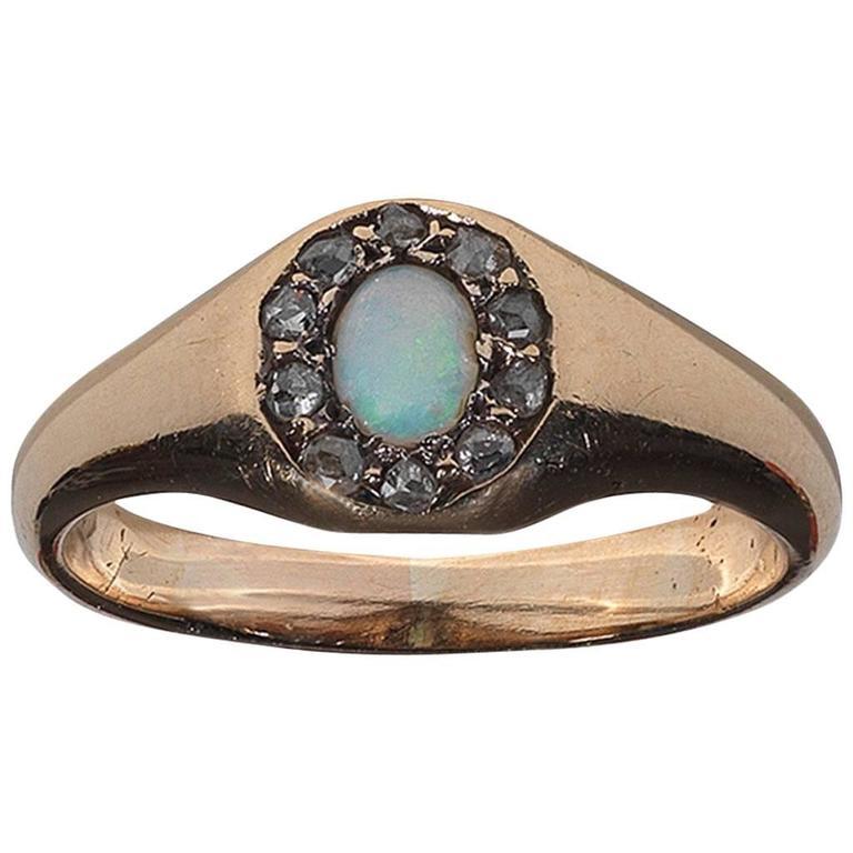 BERNARDO ANTICHITÀ PONTE VECCHIO FLORENCE
A late 19th century opal and diamond cluster ring, circa 1870, the oval opal cabochon, within a border of rose-cut diamonds, mounted in silver and gold.
Ring size 7