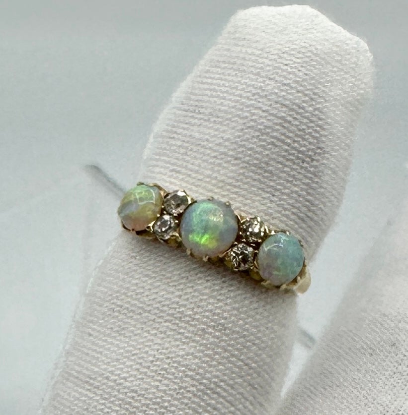 Se trata de un Antiguo Anillo de Compromiso de Boda Victoriano con tres magníficos Ópalos ovales naturales de increíble color y asombrosa belleza. Las tres gemas de ópalo están acentuadas por cuatro brillantes diamantes antiguos de talla antigua.  