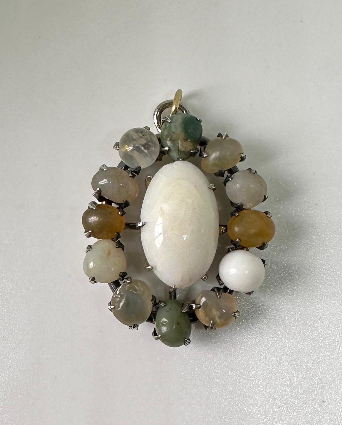Indulge in a stunning and rare antique Victorian - Art Deco Lavaliere Pendant set with a fabulous Opal Cabochon in the center and surrounded by a halo of 12 additional opals. The pendant is silver.  It is very rare to find early antique opal jewels