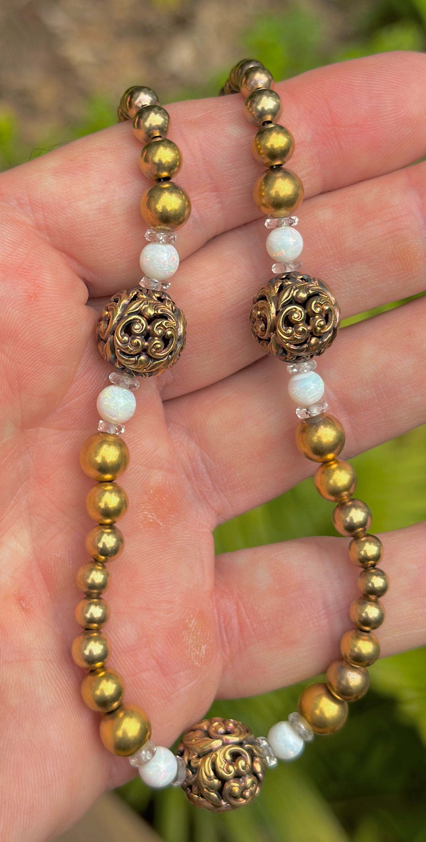 INDULGE IN THIS RARE ANTIQUE VICTORIAN OPAL, ROCK CRYSTAL AND GOLD BEAD NECKLACE.  THE EXTRAORDINARY JEWEL HAS THREE OPEN WORK GOLD ACANTHUS LEAF MOTIF BEADS OF GREAT BEAUTY.  ON EITHER SIDE OF THE FLOWER MOTIF BEADS ARE SPECTACULAR ROUND OPAL BEADS