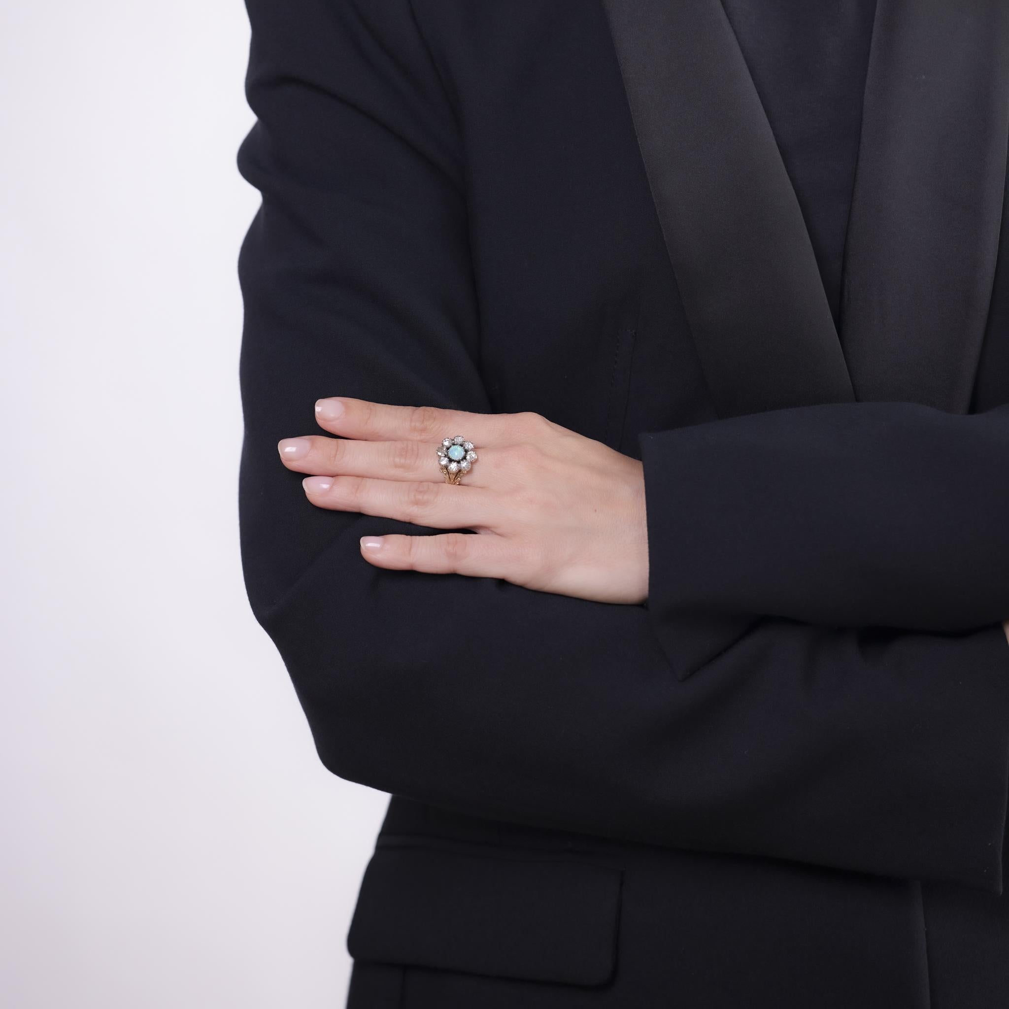Cette bague victorienne enchanteresse est ornée d'une opale cabochon brillante entourée de diamants roses étincelants. Réalisé en or jaune 14k et en argent, il rayonne d'un charme antique et d'une élégance intemporelle.