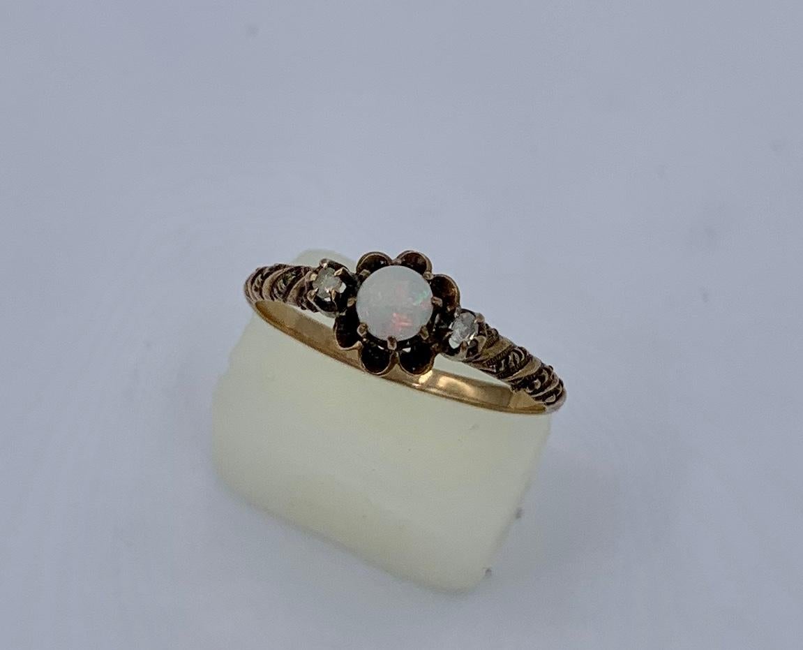 This is a gorgeous antique Victorian natural Opal Ring with two Rose Cut Diamonds of stunning beauty.
The sparkling round Opal cabochon has yellow, green, and orange fire.  The Opal gem is accented by two antique Rose Cut Diamonds.   The opal is set