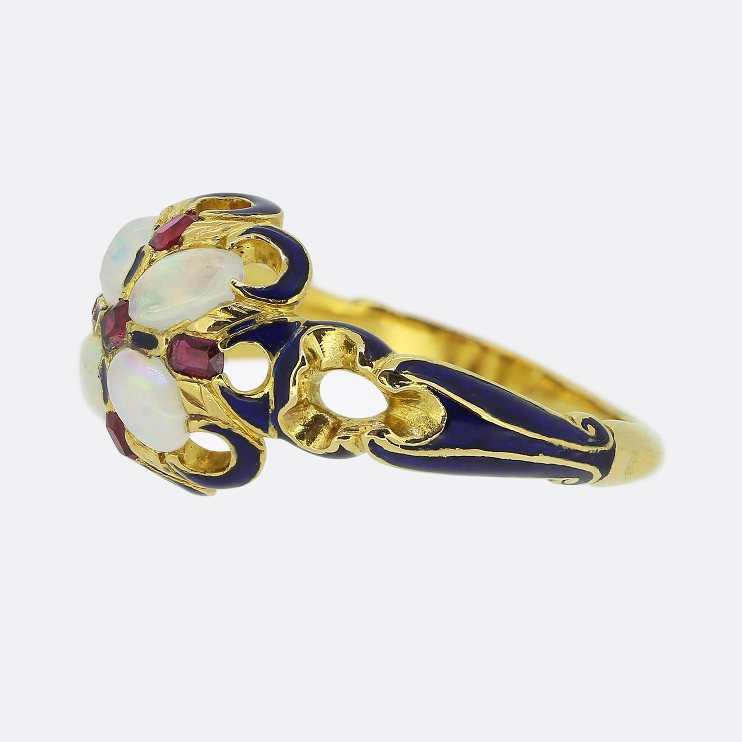 Hier haben wir einen wunderschönen viktorianischen Clusterring. Dieses antike Stück wurde aus reichhaltigem 18-karätigem Gelbgold gefertigt und zeigt einen offenen, gewölbten Kopf, der vier weiße Opale beherbergt, die in Blau-, Rosa- und Orangetönen