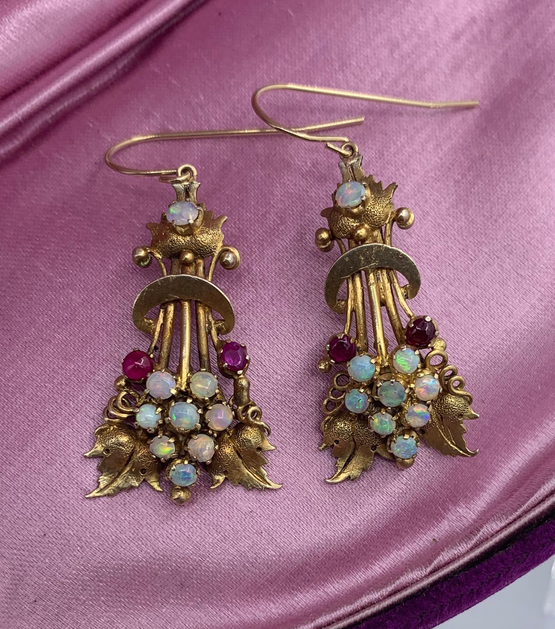 A spectacular pair of Opal and Ruby early Antique Etruscan Revival Victorian leaf motif Pendant Dangle Drop Earrings in 14 Karat Gold.   These antique earrings are of the highest quality.  They have extraordinary neoclassical Etruscan design of a