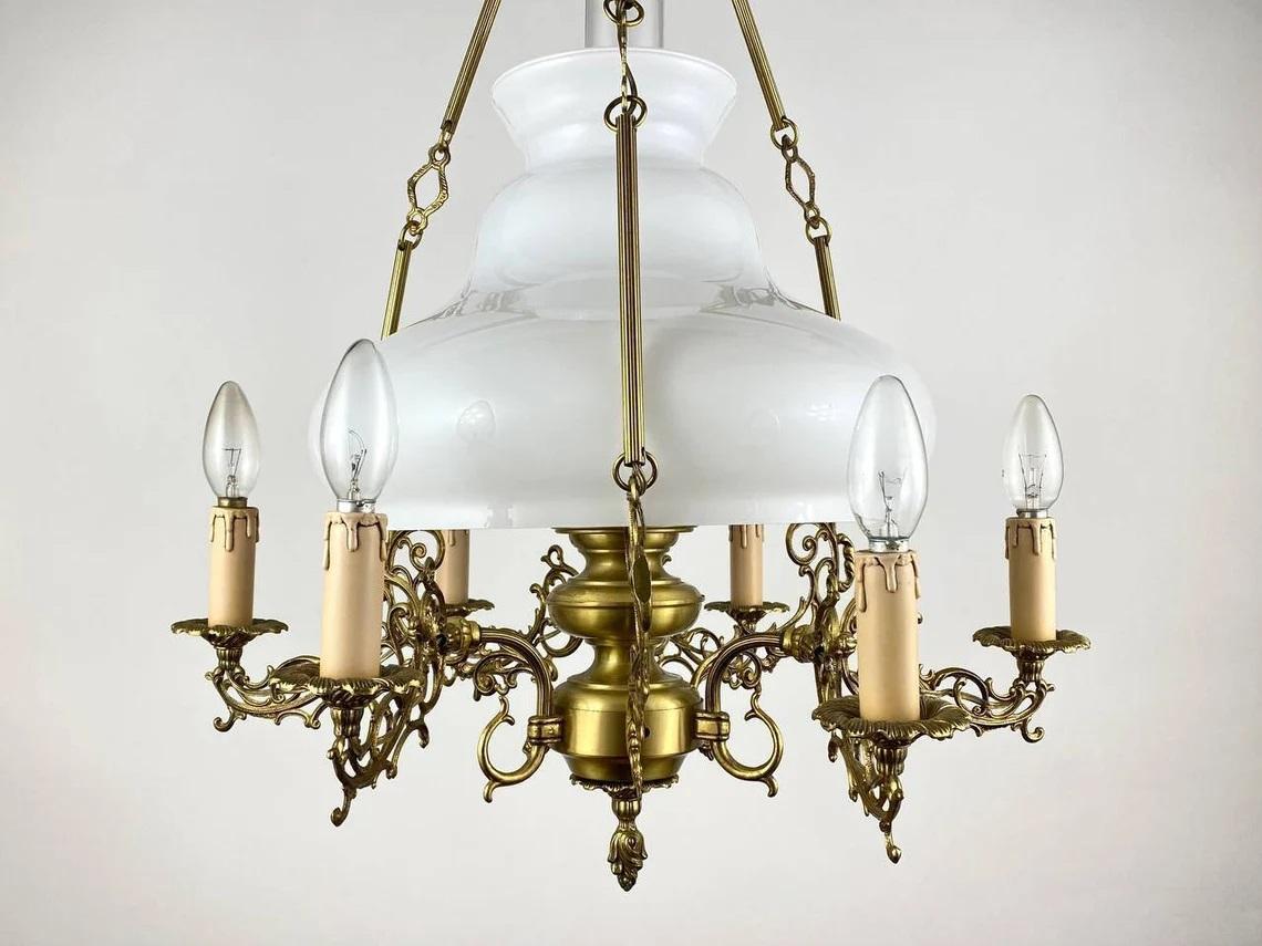 This vintage French Victorian Style chandelier 20th century.

The chandelier is made of brass, opaline glass and clear glass shades and fake candles.
Amazing attention to detail the arms, frame and chains are all highly decorated and