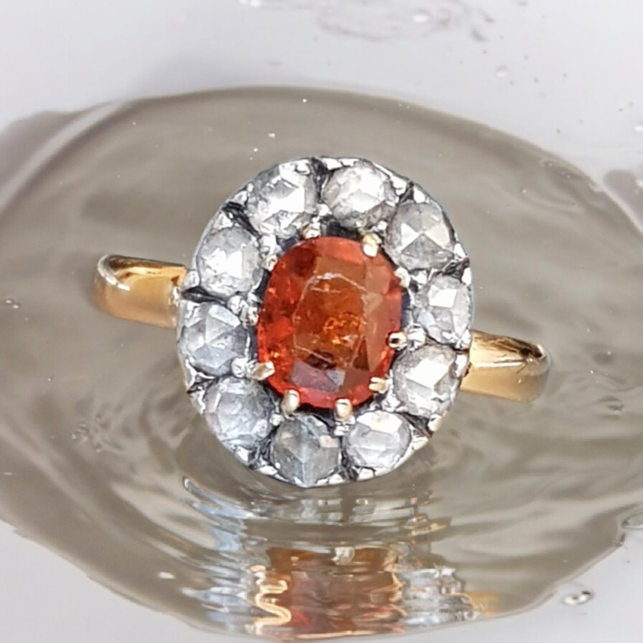 Viktorianischer Orange Spessartine Granat und Diamant Coronet Cluster Ring in Silber und 18kt Gelbgold. 
In der Mitte mit einem ovalen Spessartit im Mischschliff besetzt  feurig-orange glühend, messend:  7,60 mm x 6,20 mm x 3 mm (ca.)  1,10 Karat),