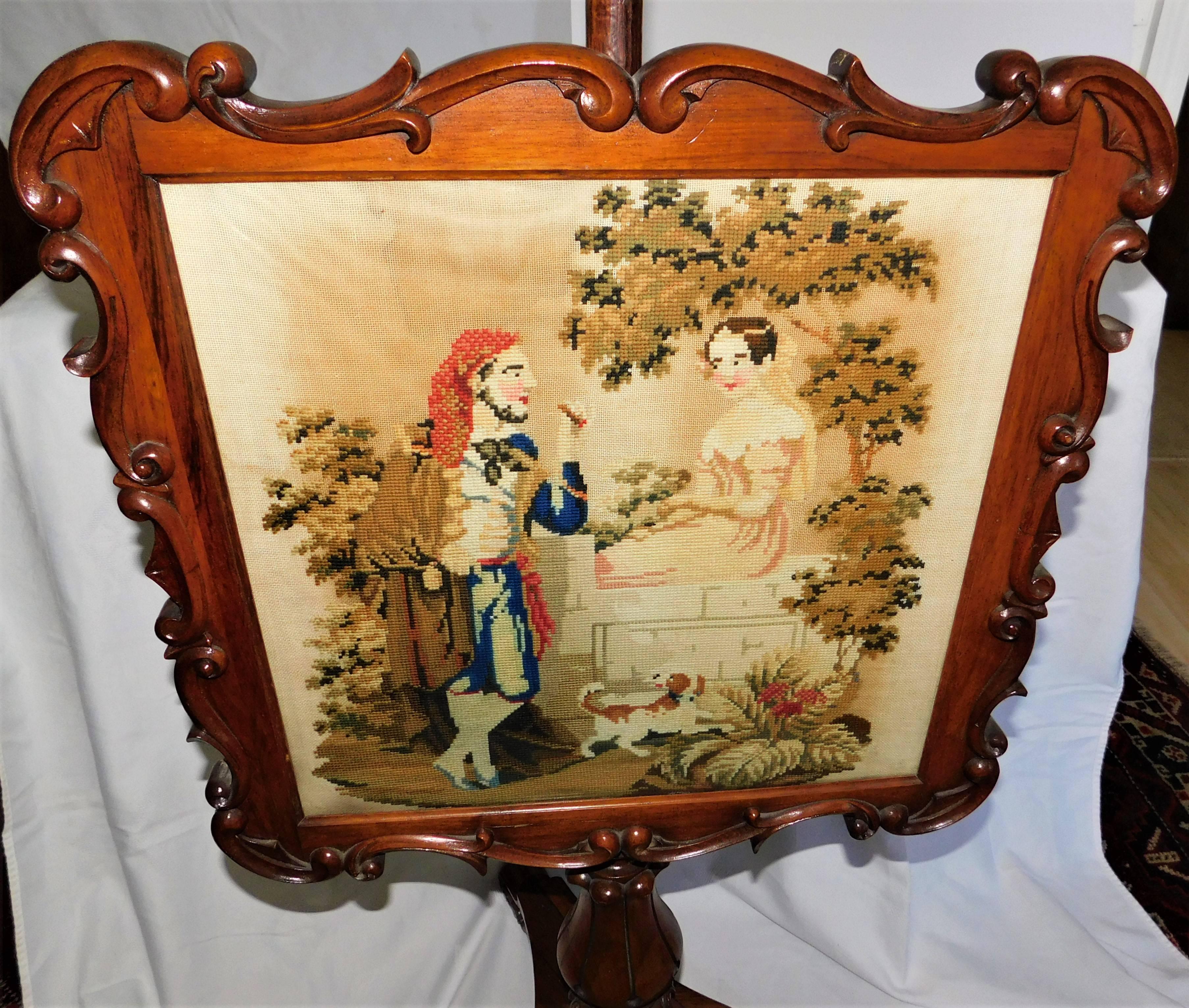 Antique Victorian floor fire screen with mahogany frame stands on three mahogany legs Romeo and Juliet type scene embroidery design, English, circa 1860.