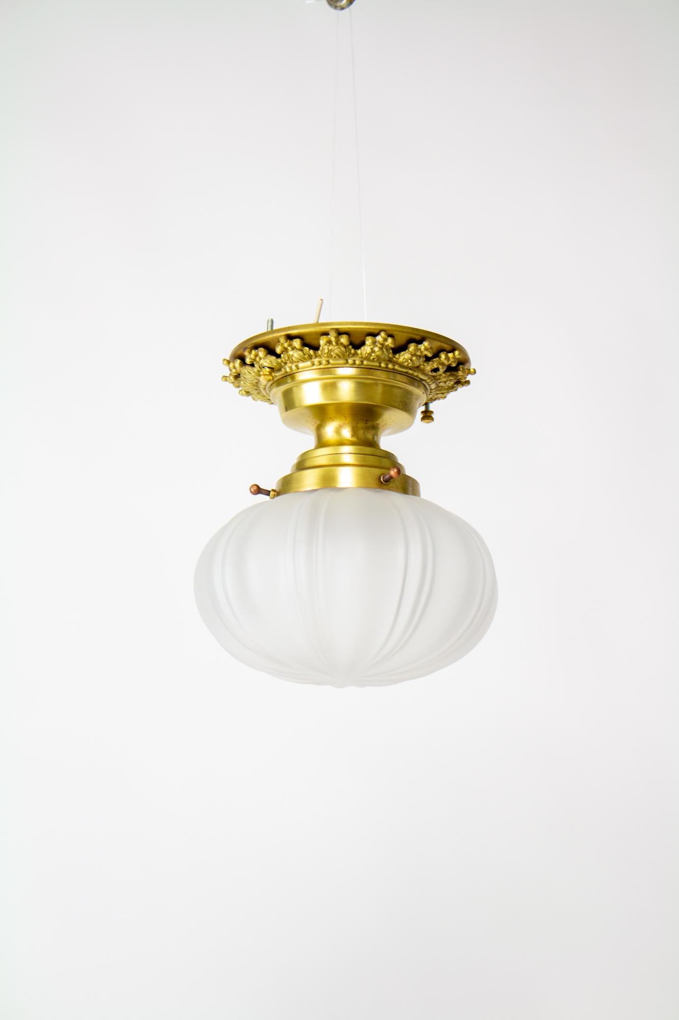 Victorian ornate flush mount with onion glass. Brass fixture has a pretty ring of decorative brass. Glass is a frosted cast glass in an onion shape. Glass in very good condition. Fixture in good condition, polished and protected, with a satin
