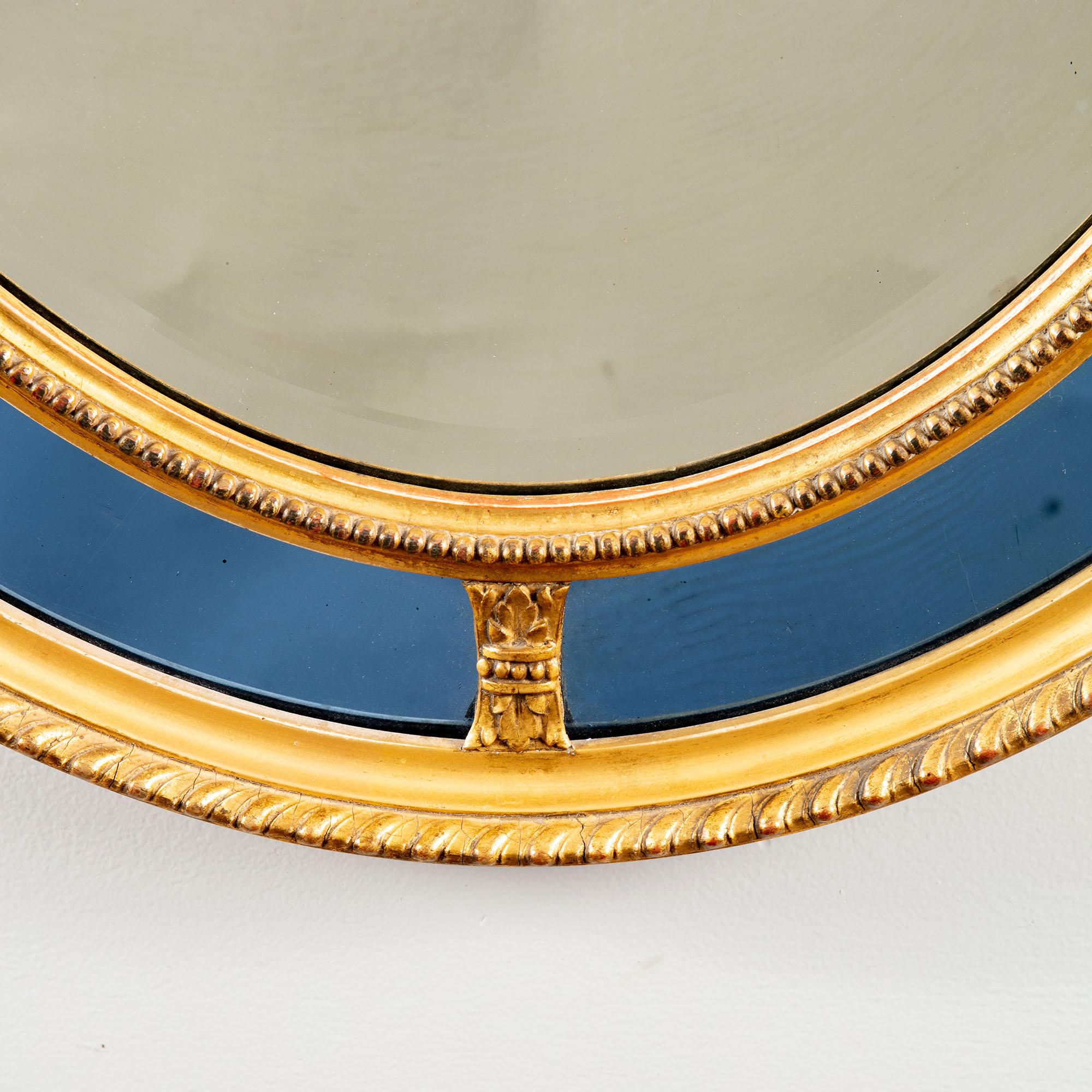 A fine mid-19th century neoclassical giltwood oval mirror with light blue border glass.

England, circa 1870

Measures: Height 33 ins / 84cm

Width 25 ins / 63.5 cm.