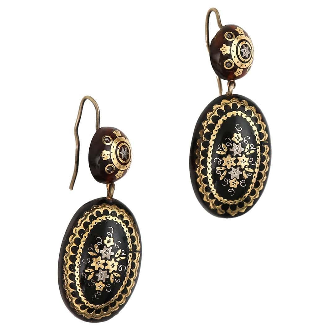 A fabulous pair of antique Victorian pique gold and silver inlaid earrings that can be dated to the height of their fashion circa 1880. These beautiful antique drop earrings are formed on a large oval drop with intricate detailing of floral and