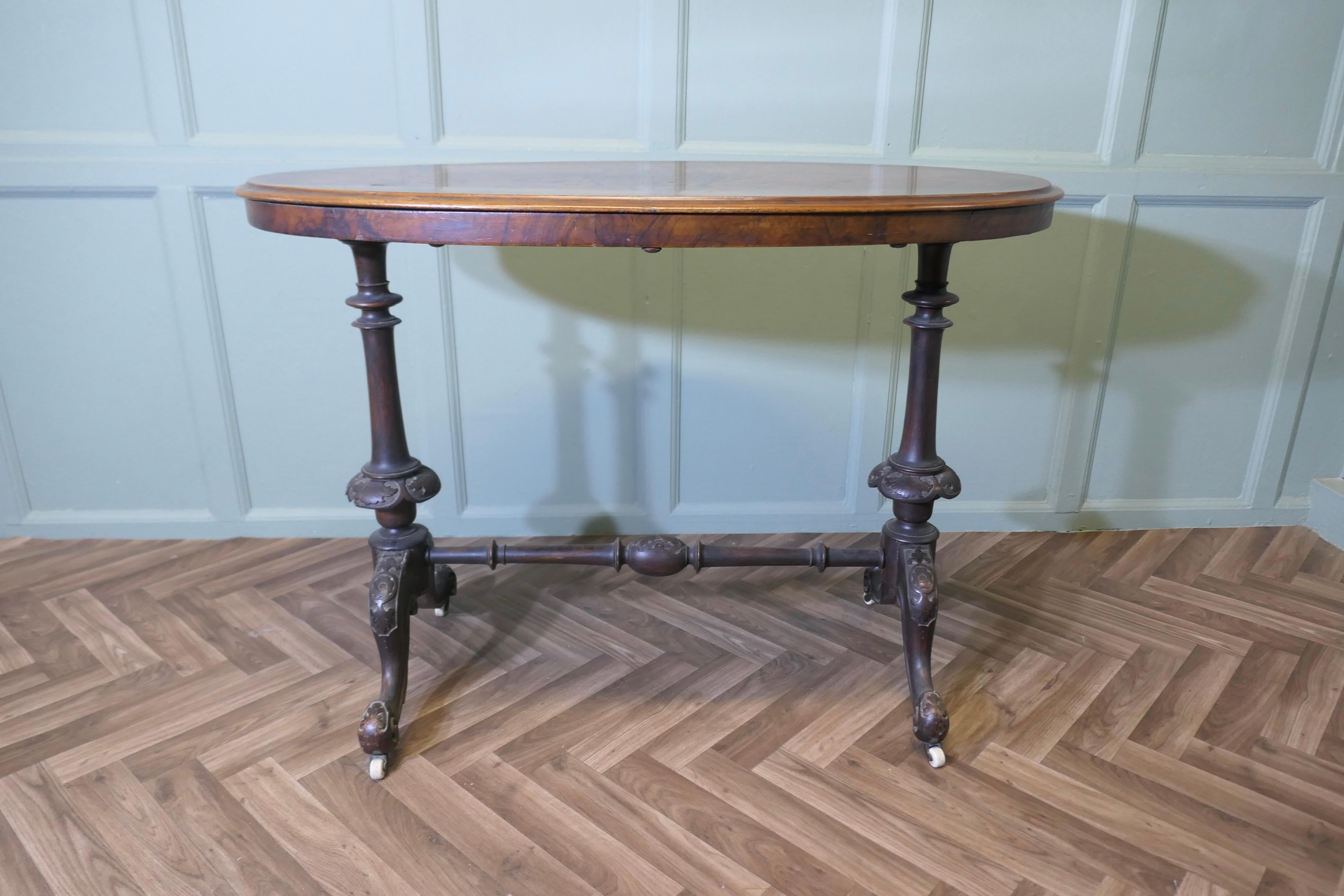 Table de centre ou de hall ovale en noyer de l'époque victorienne  

La table a de très beaux pieds sculptés montés sur des roulettes en céramique. Le plateau de la table est en noyer avec un bord moulé.  qui est très attrayante elle porte encore