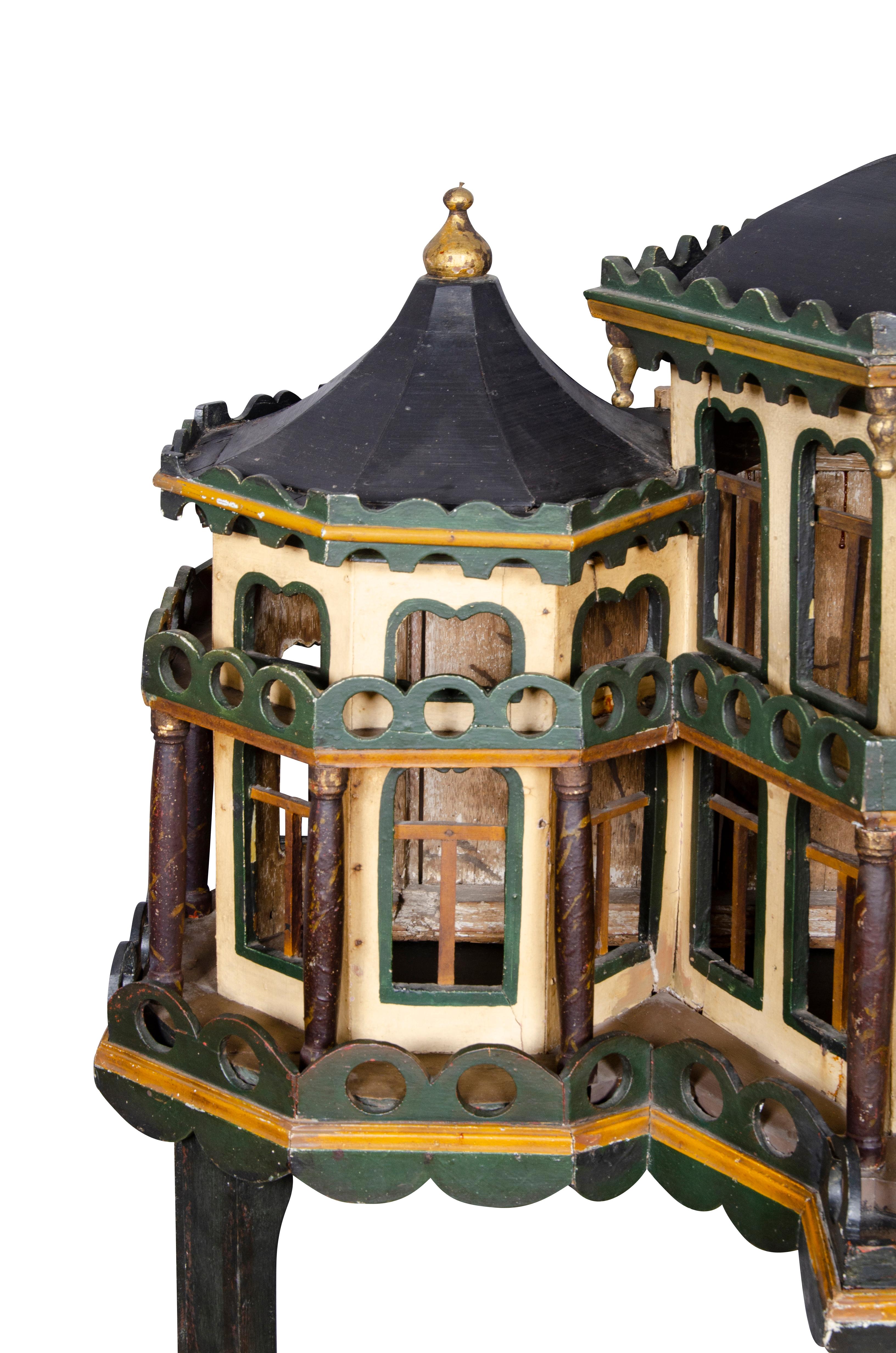Featured as a house with central dome and cupola flanked by a pair of pagoda form wings. Green, cream and black painted decoration. Later painted wood base.