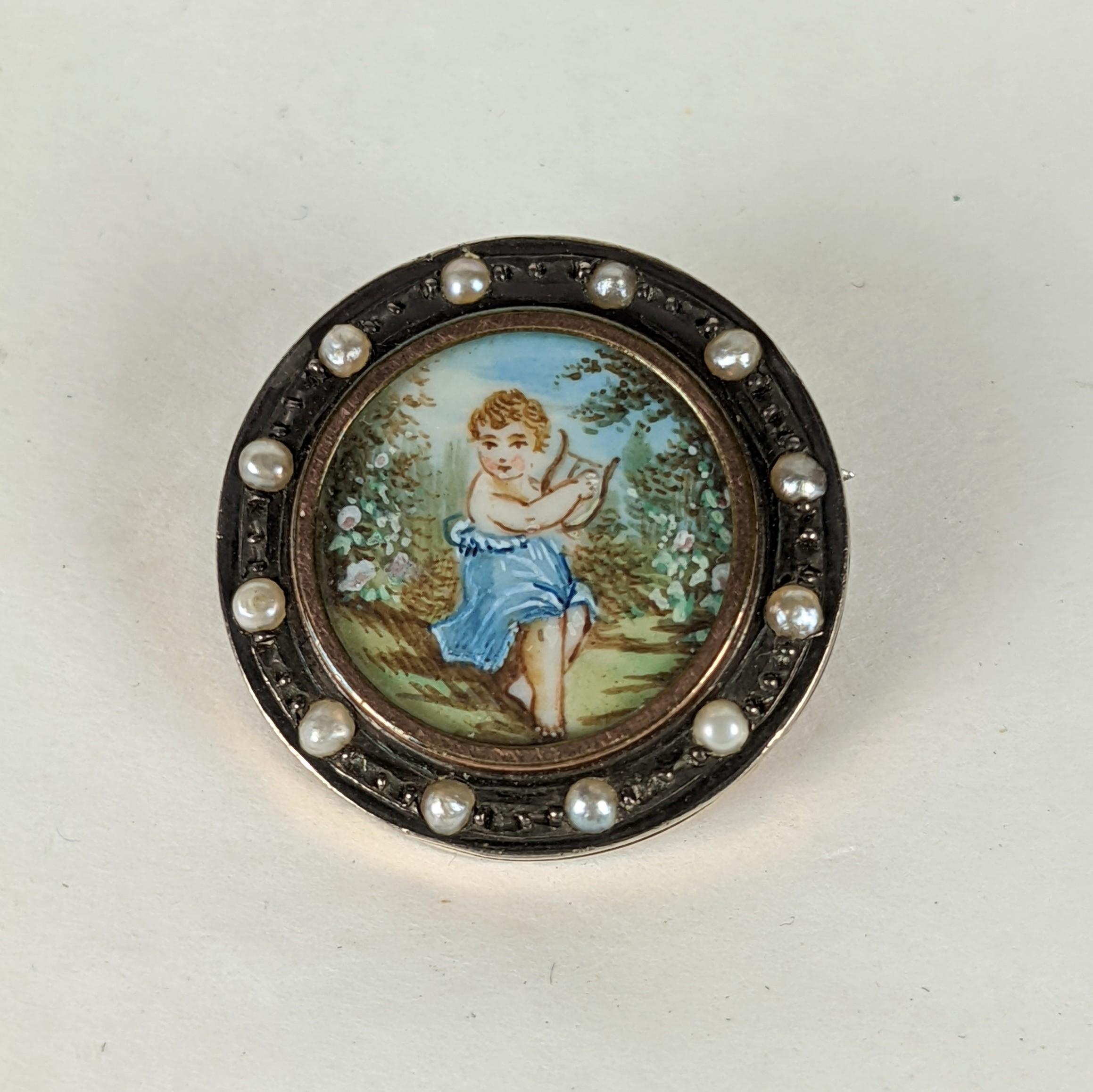 Charming Victorian Painted Miniature Brooch with a surround of half pearls. A finely painted miniature watercolor of a young child playing a harp in the woods is set under glass. The pearls are set in silver and the backing is gold filled metal. 