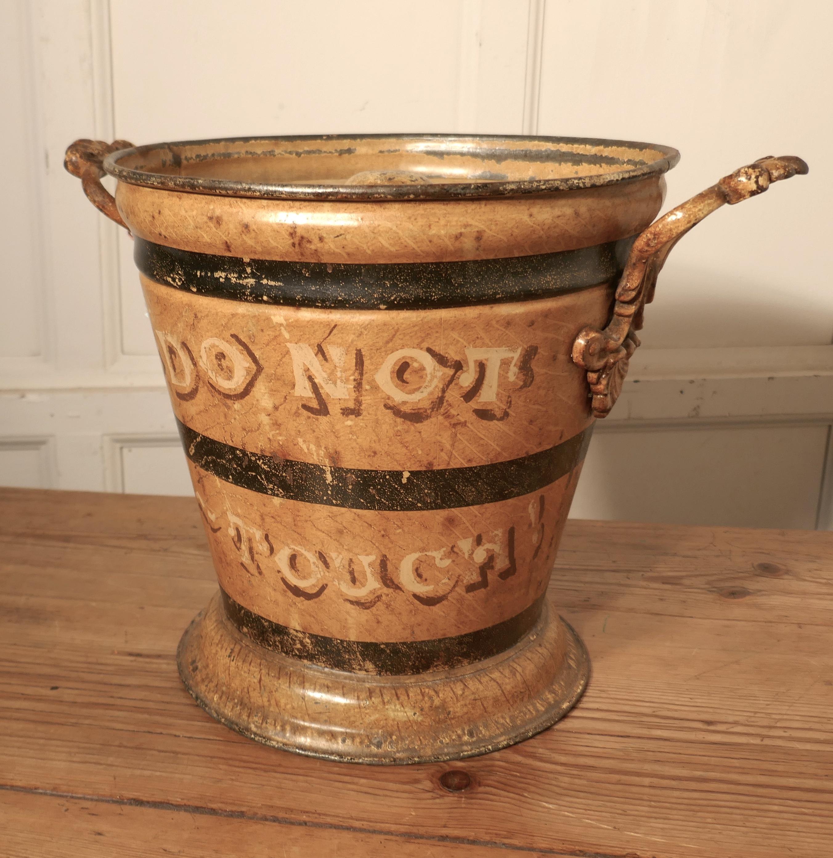 Victorian painted tin ash can or cinder bucket

A great looking piece, it is in scumble paint with “DO NOT TOUCH” on one side and “CINDERS AND HOT ASHES” on the reverse, all a bit worn but to be expected on such an old piece
The bucket has a