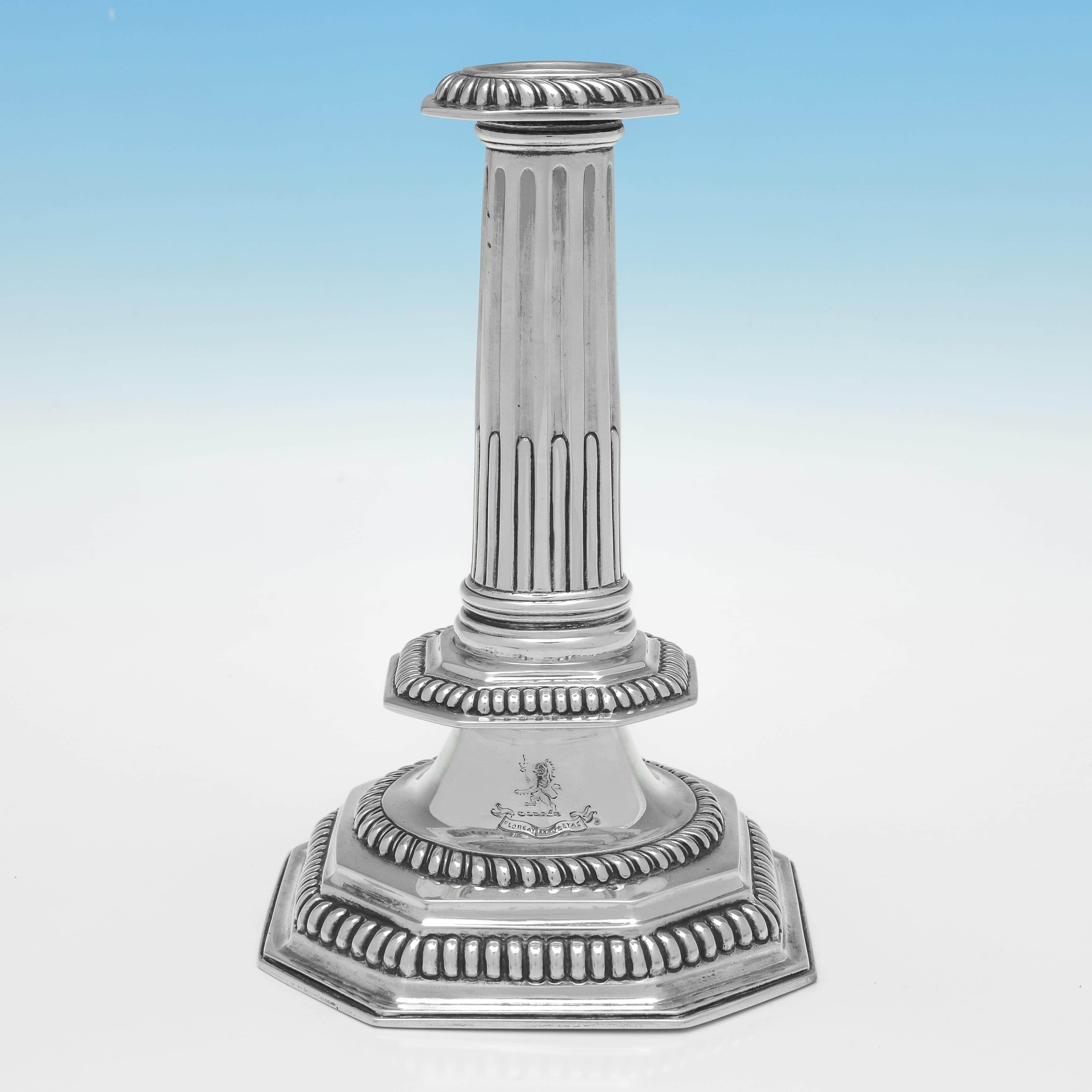 Hallmarked in London in 1875 by John Henry Williamson, this charming pair of Victorian, Antique Sterling Silver Candlesticks, are fine reproductions of a William & Mary period design, and each are engraved with a crest and motto. Each candlestick