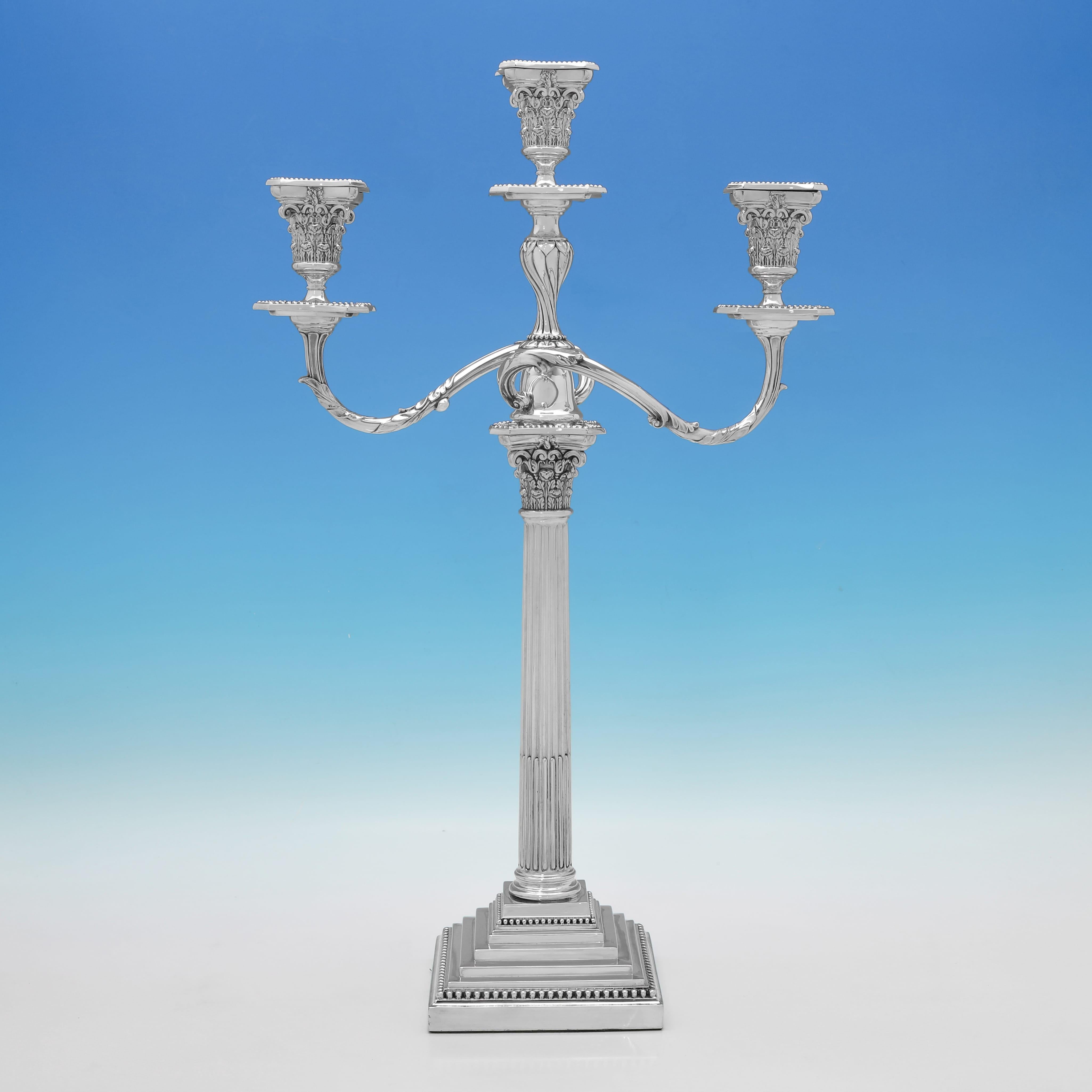 Marcado en Sheffield en 1894 por James Dixon & Sons, este hermoso par de candelabros victorianos de plata de ley antigua tienen un diseño de columna corintia, sostienen tres velas y presentan bases escalonadas con bordes de cuentas. Cada candelabro