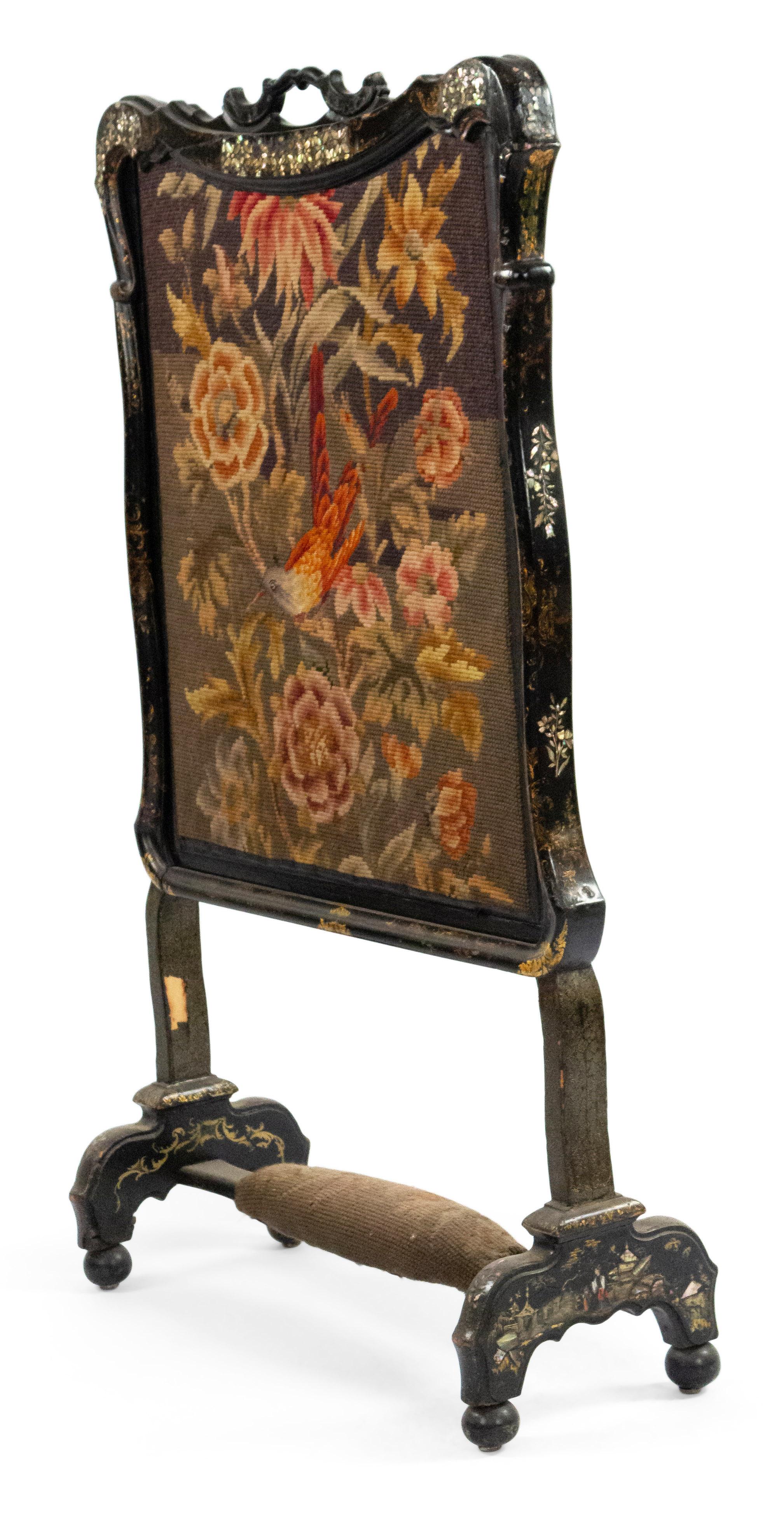 English Victorian papier-mâché pearl inlaid black lacquered fire screen with needlepoint panel depicting a bird sitting on a floral spray.
