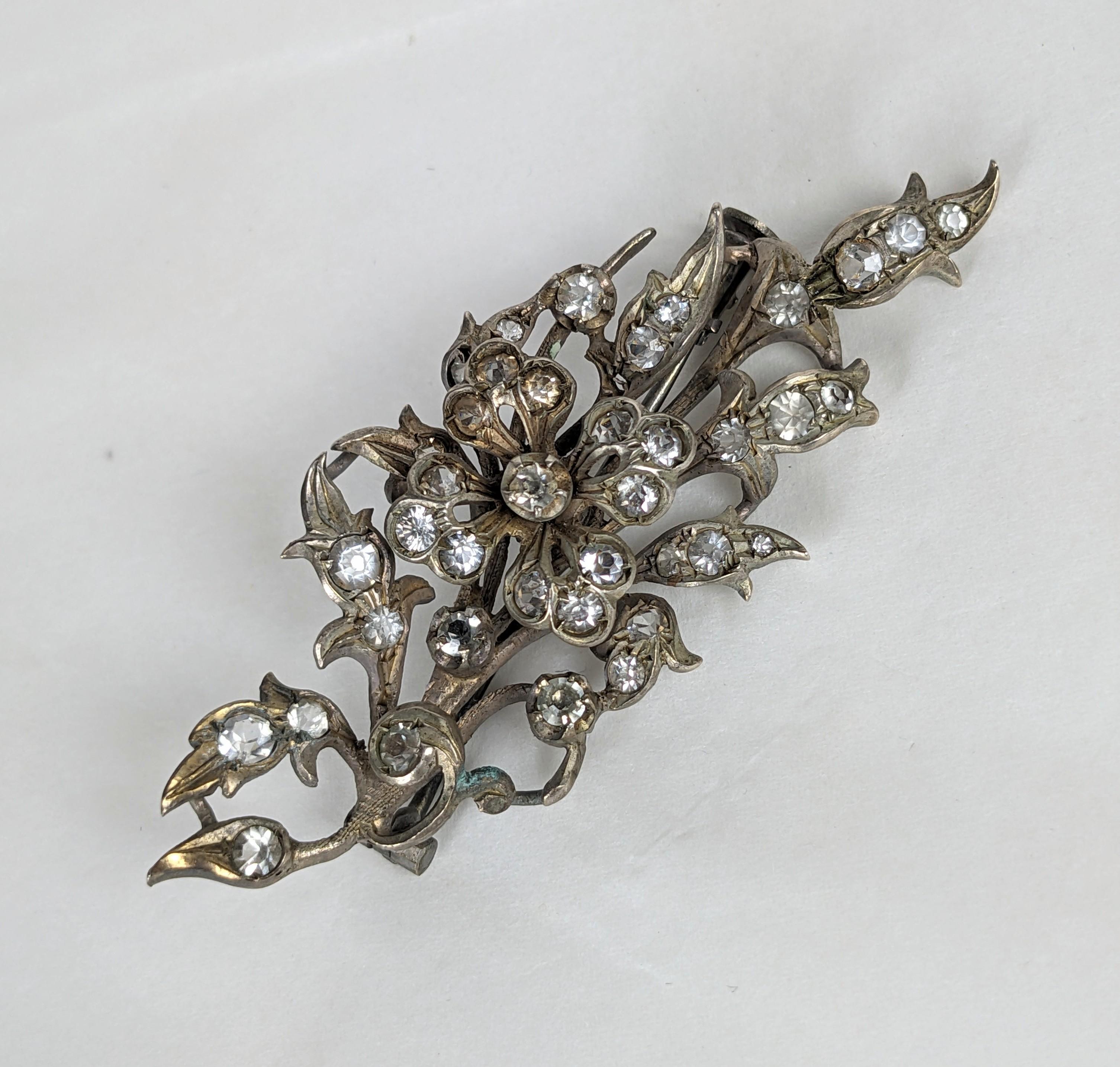 Elegante broche victoriano floral de pasta del siglo XIX. 
La cabeza de la flor tridimensional está engastada en un rocío de hojas y capullos engastados con pastas. Sello de plata francesa del siglo XIX. 
Francia de 1880. 2.5