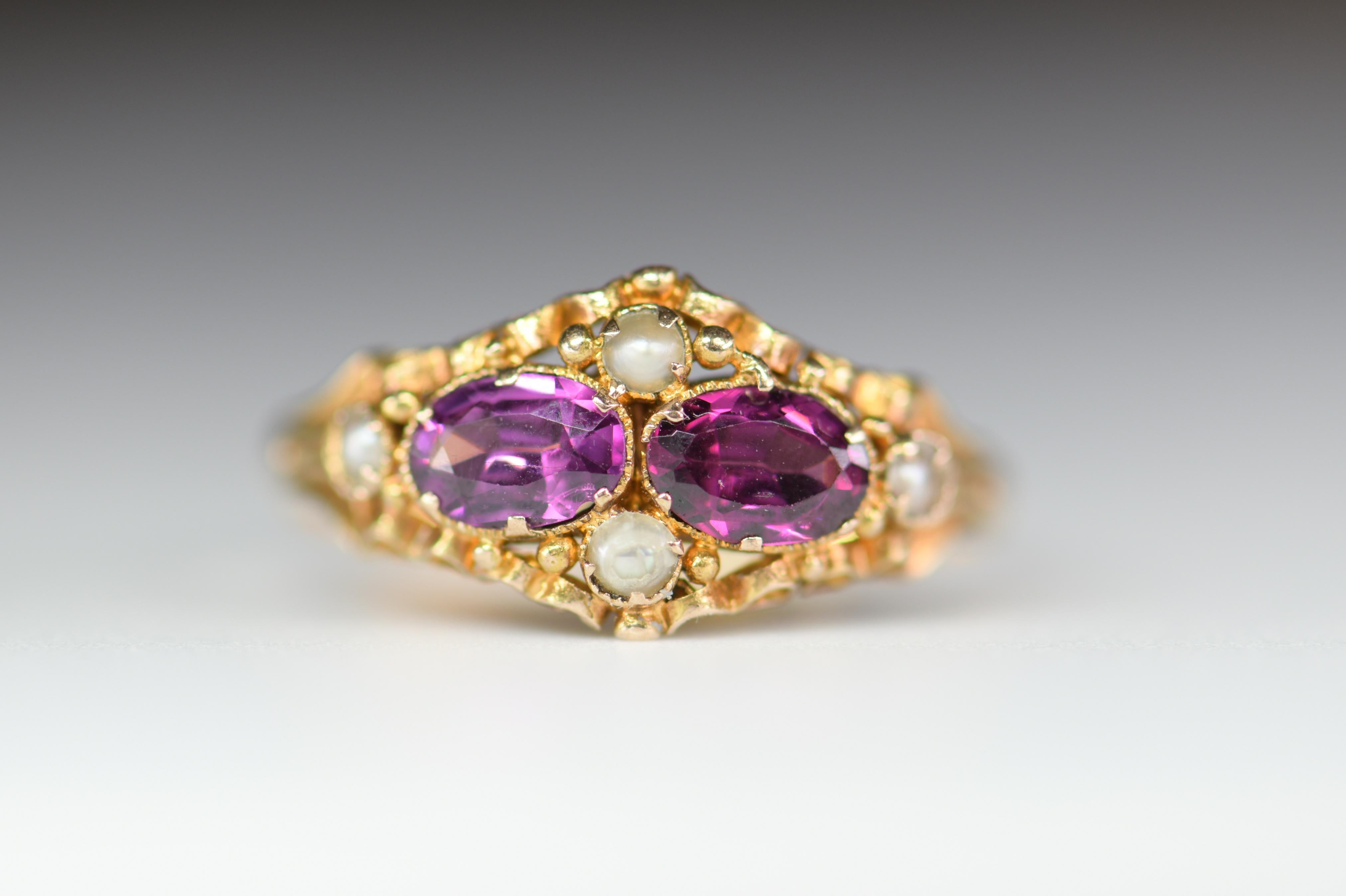 This beautiful Victorian English ring features two amethysts accented with seed pearls set in 15KT gold. Amethyst is a calming stone, which promotes balance and peace. Circa Birmingham 1865.

The 15 and .625 stamps show that it is 15K gold and that