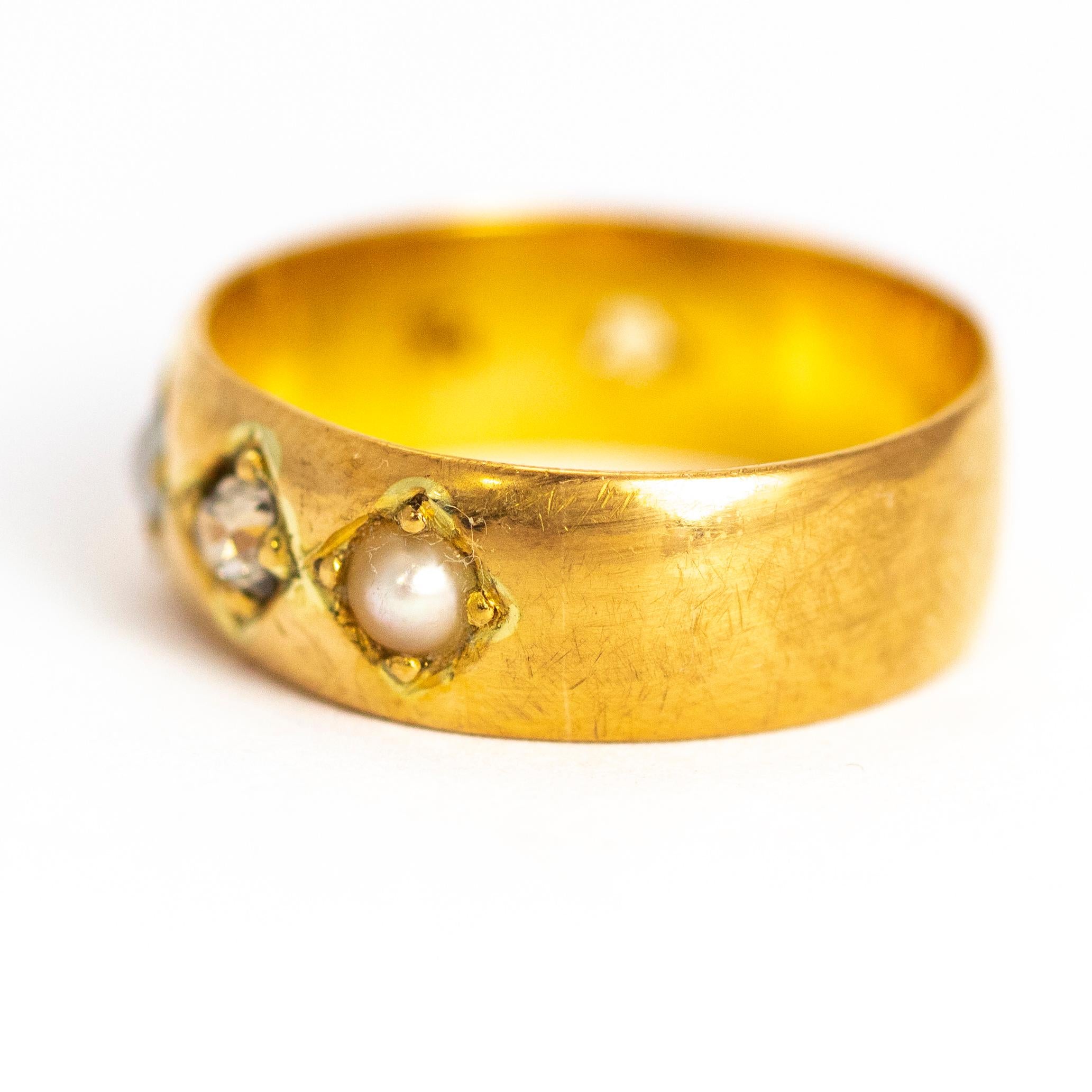 This chunky 22ct gold band holds a lovely 20pt diamond that sits in between two sweet pearls. This ring could make a decorative wedding band or a lovely everyday wear. Made in Birmingham, England.

Ring Size: R or 8 1/2