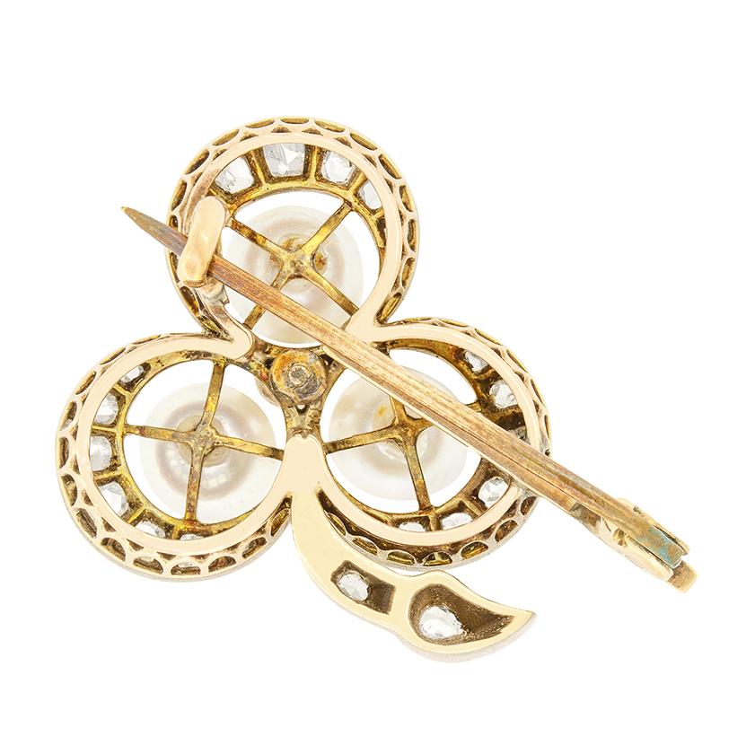 Taking on a wonderful three leaf clover design, this Victorian brooch has been intricately crafted in 15 carat gold and silver. At the heart of each leaf sits a pearl, each 6.4mm in diameter, surrounded by a collection of rose cut diamonds. Each set