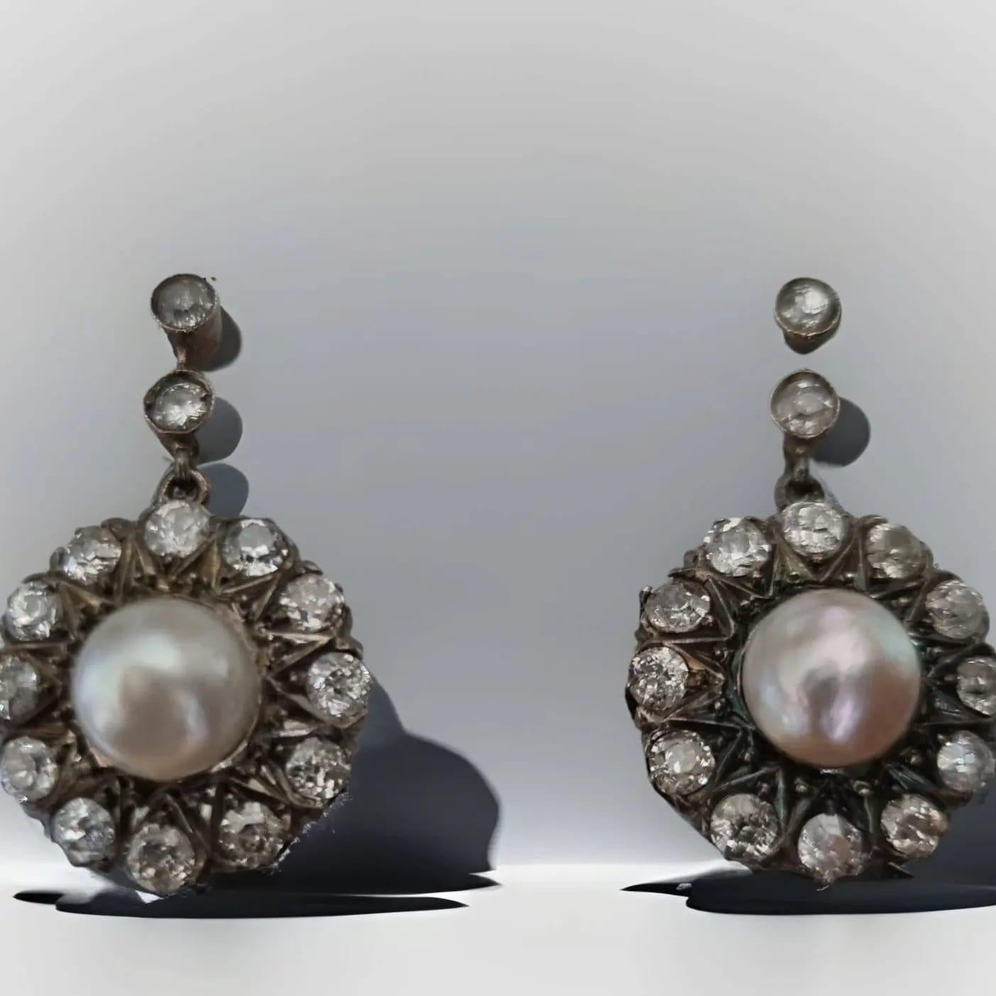 Boucles d'oreilles pendantes victoriennes en perles et diamants (19ème siècle)
Les diamants de taille européenne, brillants et étincelants, descendent comme des gouttes de rosée, centrés par des perles de couleur blanche lumineuse.  et un orient
