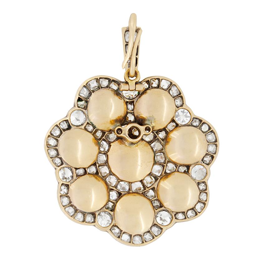 This magnificent pearl and diamond pendant dates back to the Victorian era. A natural 6mm pearl sits central to the piece with seven 5.5mm pearls surrounding. In between these pearls, haloing each of them, swell as set along the bale, are a total of