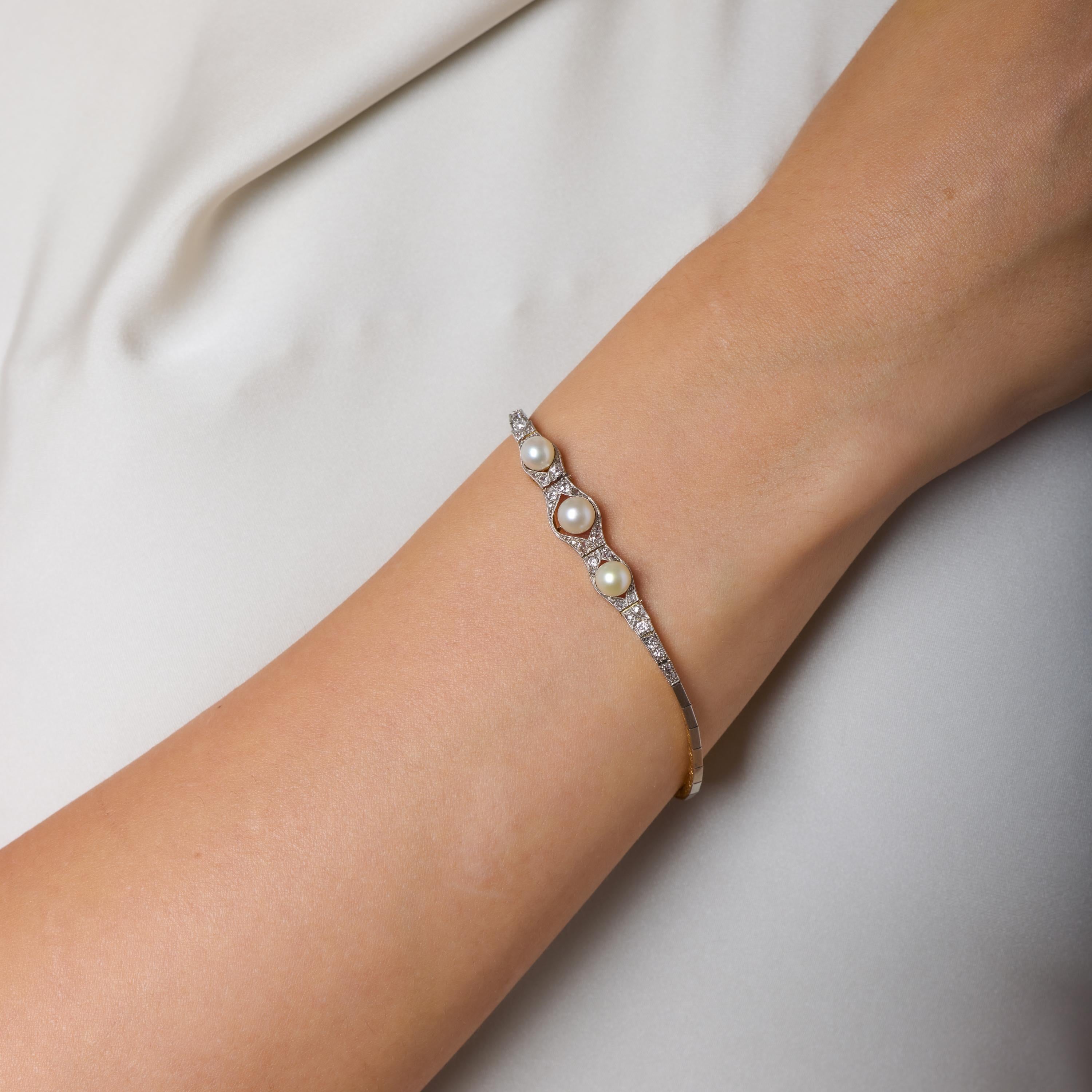 Este encantador brazalete victoriano combina luminosas perlas naturales con el suave brillo de diamantes talla rosa y mina vieja, creando una refinada armonía de textura y luz. Las perlas brillan con suave elegancia, mientras que los diamantes