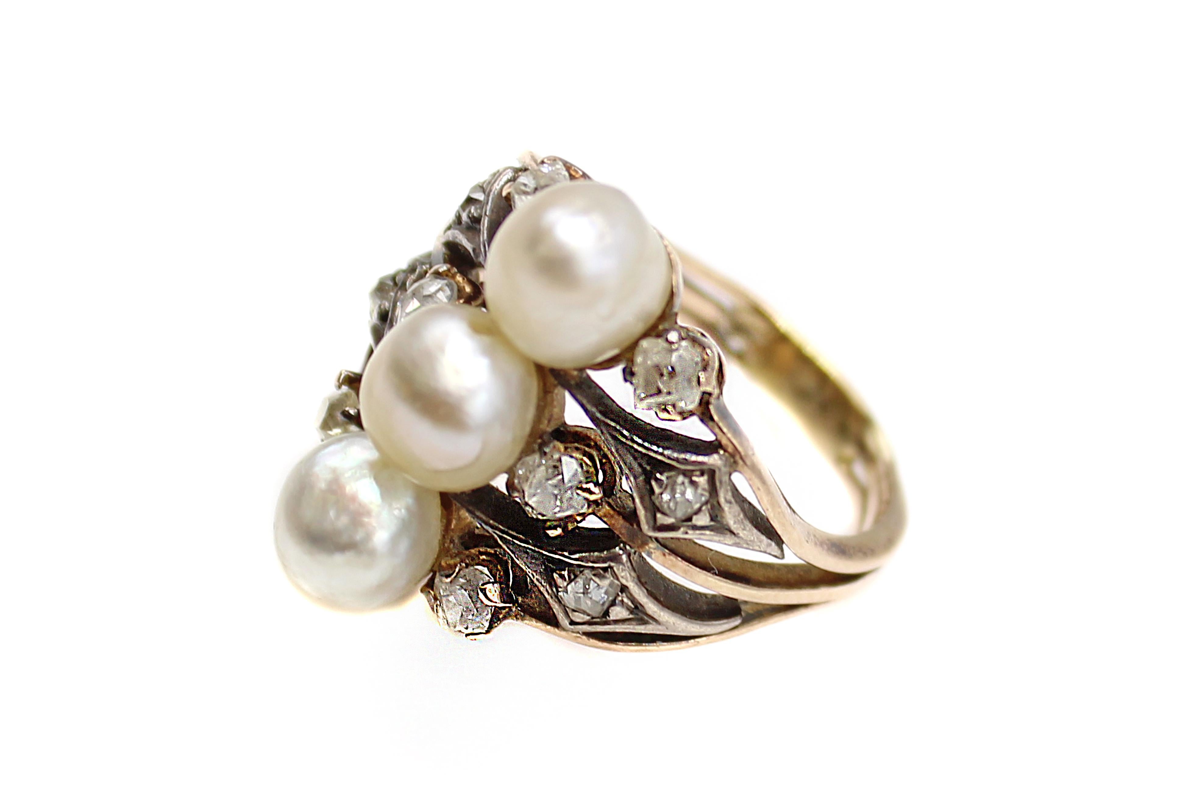 This charming Antique Victorian old cut diamond and pearl ring from ca. 1870 is gorgeous was beautifully hand-crafted in silver topped gold which was customary in this period. Three slightly baroque pearls, set up and down the finger are the center