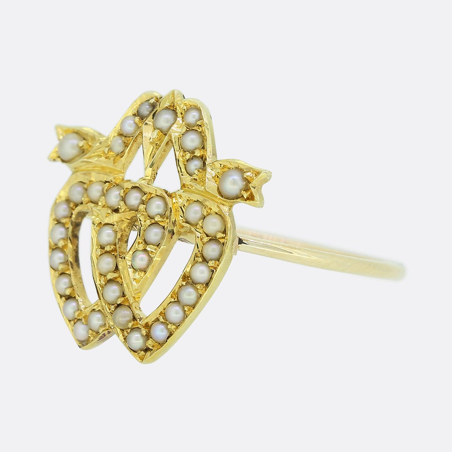 This is a lovely antique double heart ring. The ring features two interlocking hearts which have been set natural seed pearls and crafted in 15ct yellow gold with a plain band. This ring started life as an antique Victorian brooch but has been