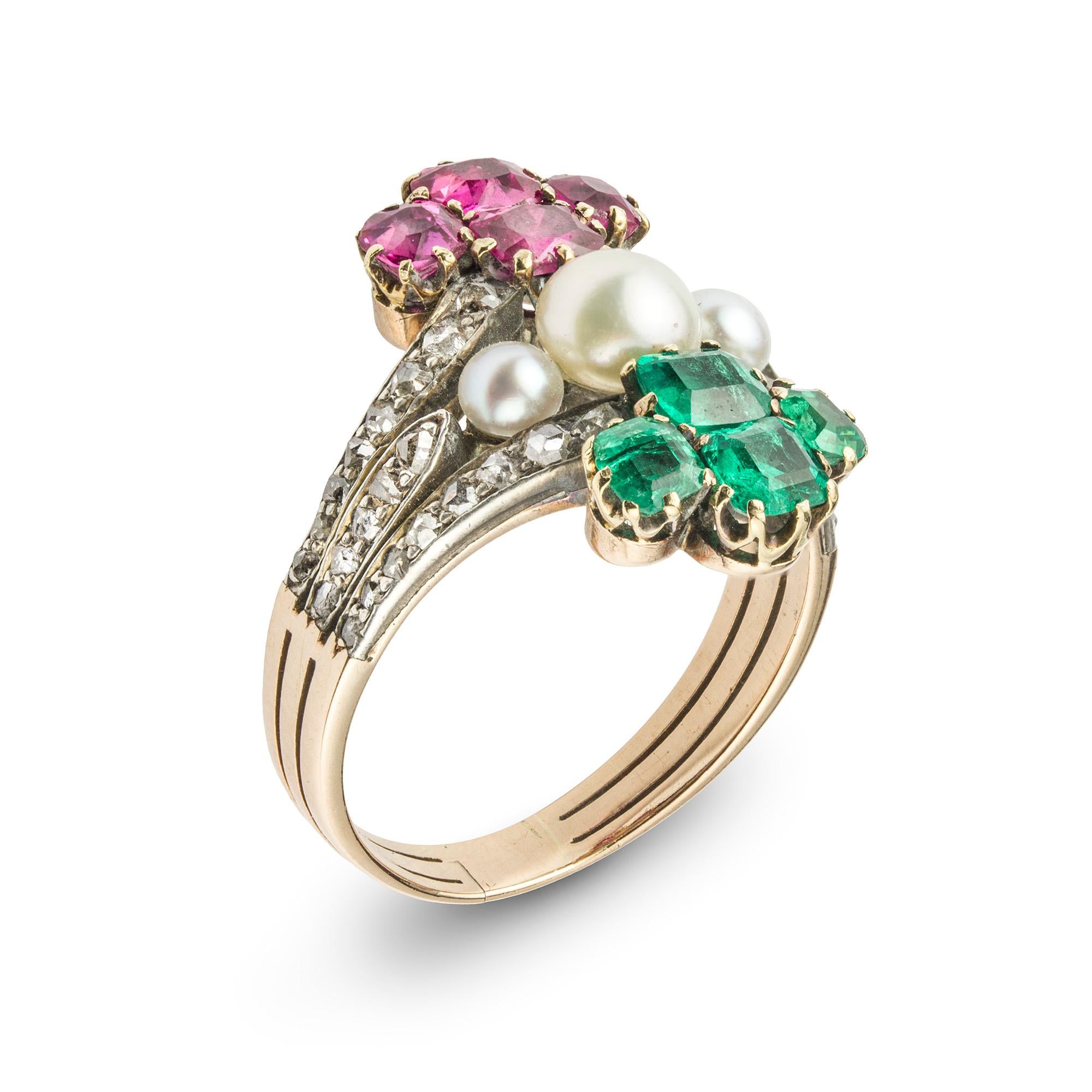 A mid nineteenth century emerald, ruby, diamond and bouton pearl ring, comprising a claw-set emerald quatrefoil surmounting three bouton pearls in a horizontal row and with a similar claw-set ruby quatrefoil below, all mounted in vertical alignment