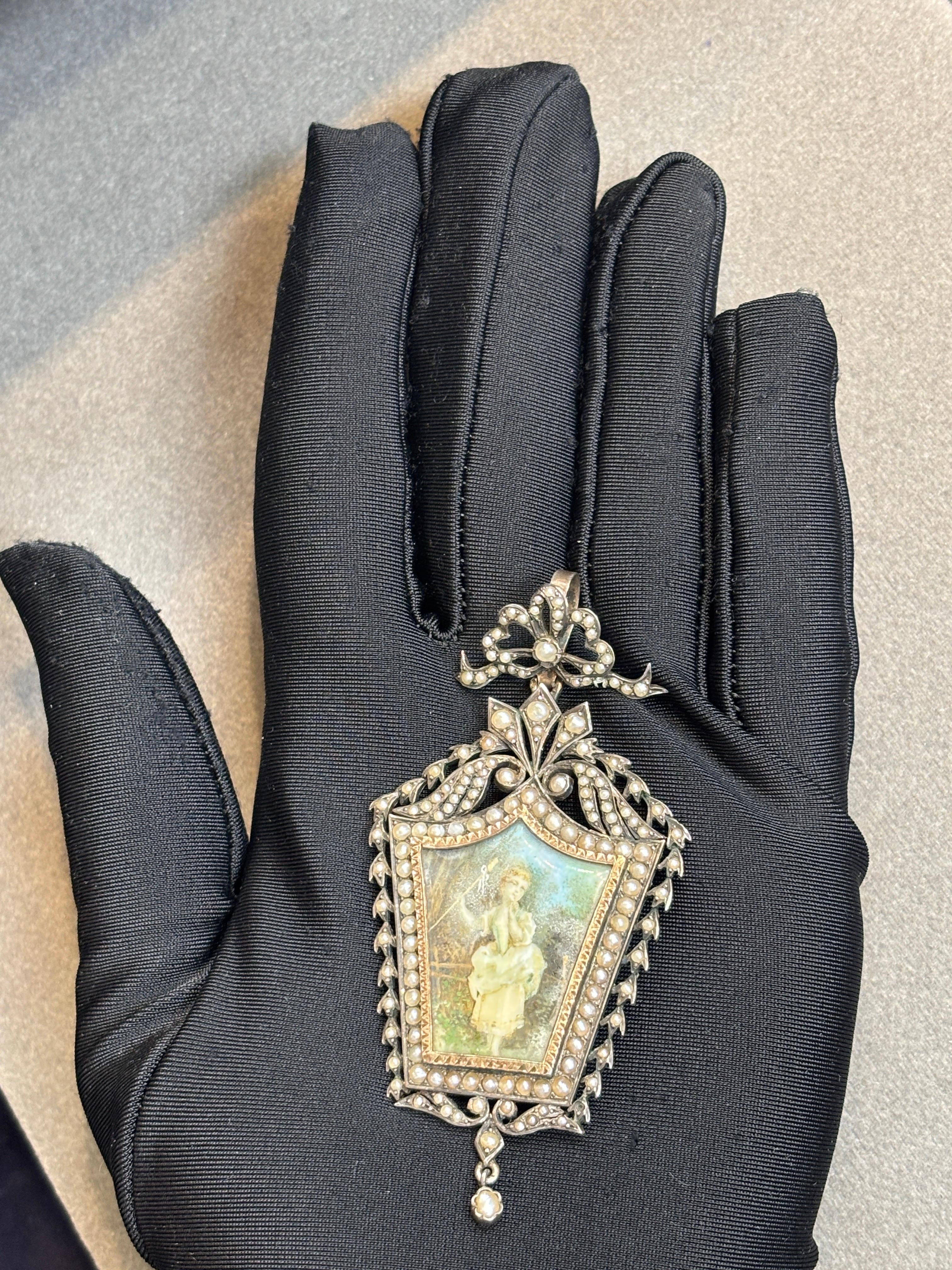 Colgante de perlas victoriano

Colgante/broche victoriano elaborado en plata y oro amarillo, que centra un retrato en miniatura pintado a mano bajo cristal. El marco ornamentado está decorado con perlas. Con alfiler y enganche para llevarlo como