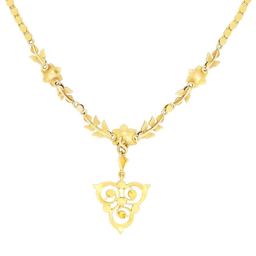 Pearls adorn almost every part of this stunning Victorian necklace. Three hand crafted, 15 carat yellow gold, flower like motifs are connected by metalwork leaves to form the mainstay of the piece, all set with pearls of varying sizes. Linked to the