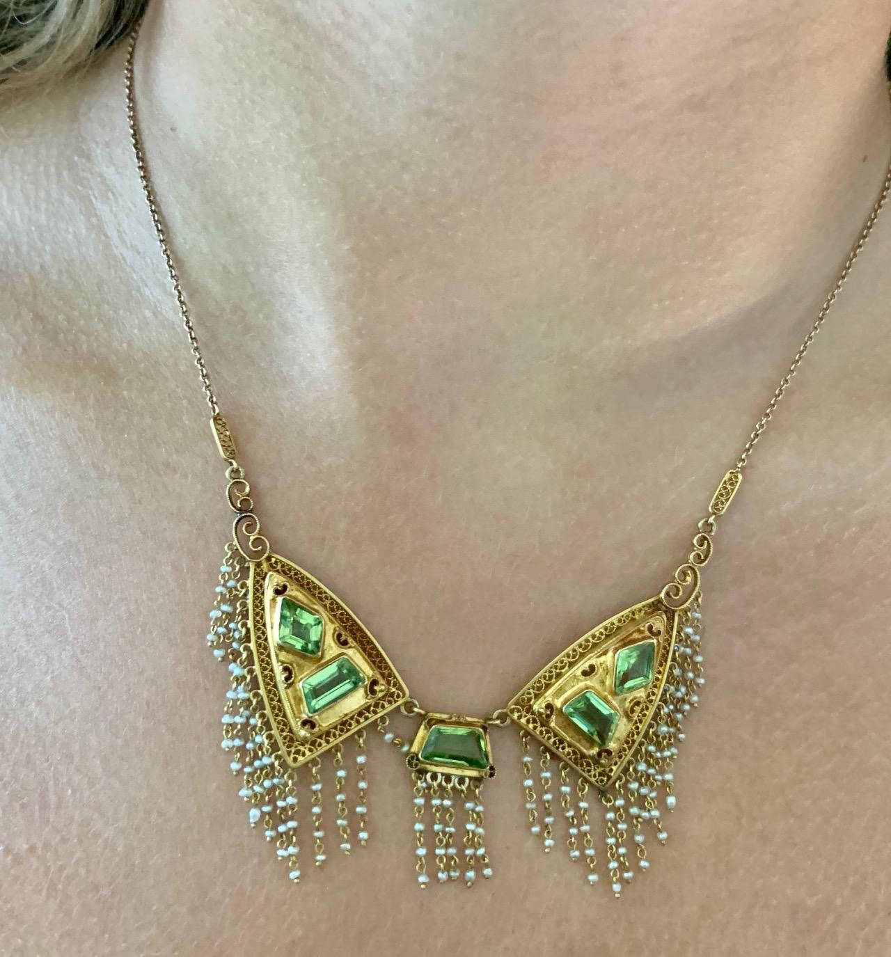 This Victorian Peridot and Seed Pearl 14k Yellow Gold necklace features six fancy cut Peridot gemstones.

It is stamped RTF.

Size:  16 1/2