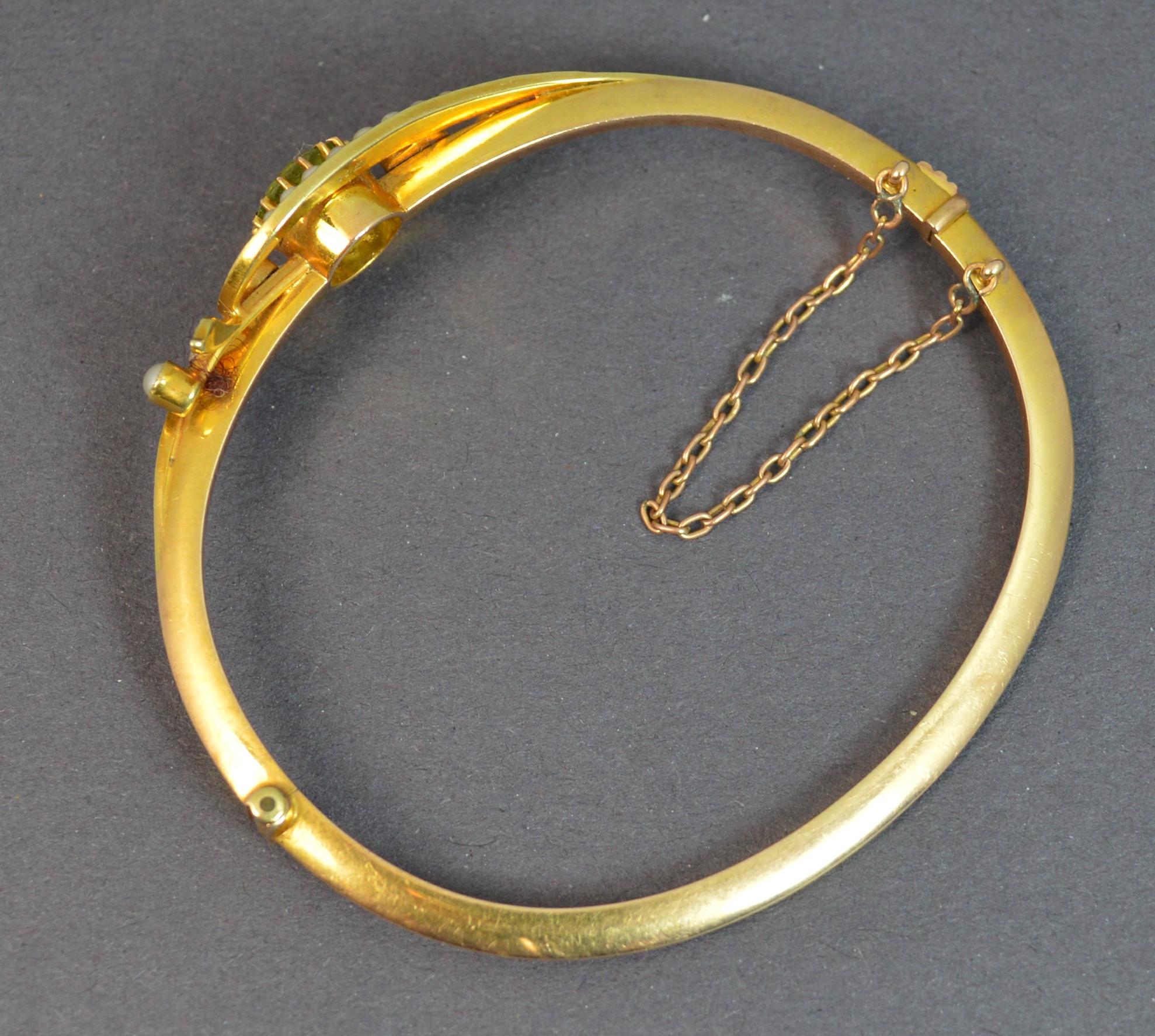 A superb Victorian period bangle. c1880.
Designed with large round peridot to centre in claw setting with pearls set surrounding in a floral like shape.
33mm spread of stones, 15mm wide head.
Modelled in a solid 15 carat yellow gold