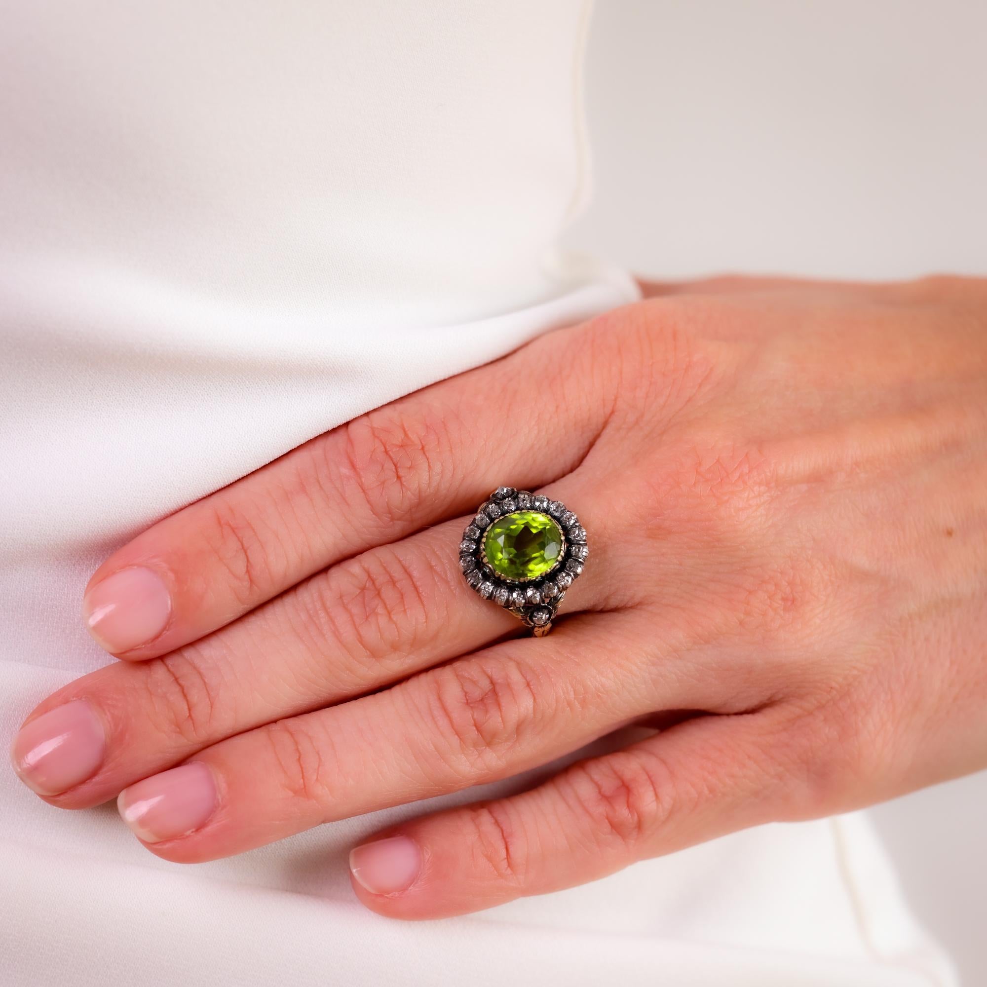 Este anillo victoriano de oro de 14 quilates de la década de 1880 exhibe un llamativo peridoto de 3 quilates, enmarcado por 22 brillantes diamantes de talla única que le confieren una refinada elegancia antigua

Piedra central: Peridoto talla
