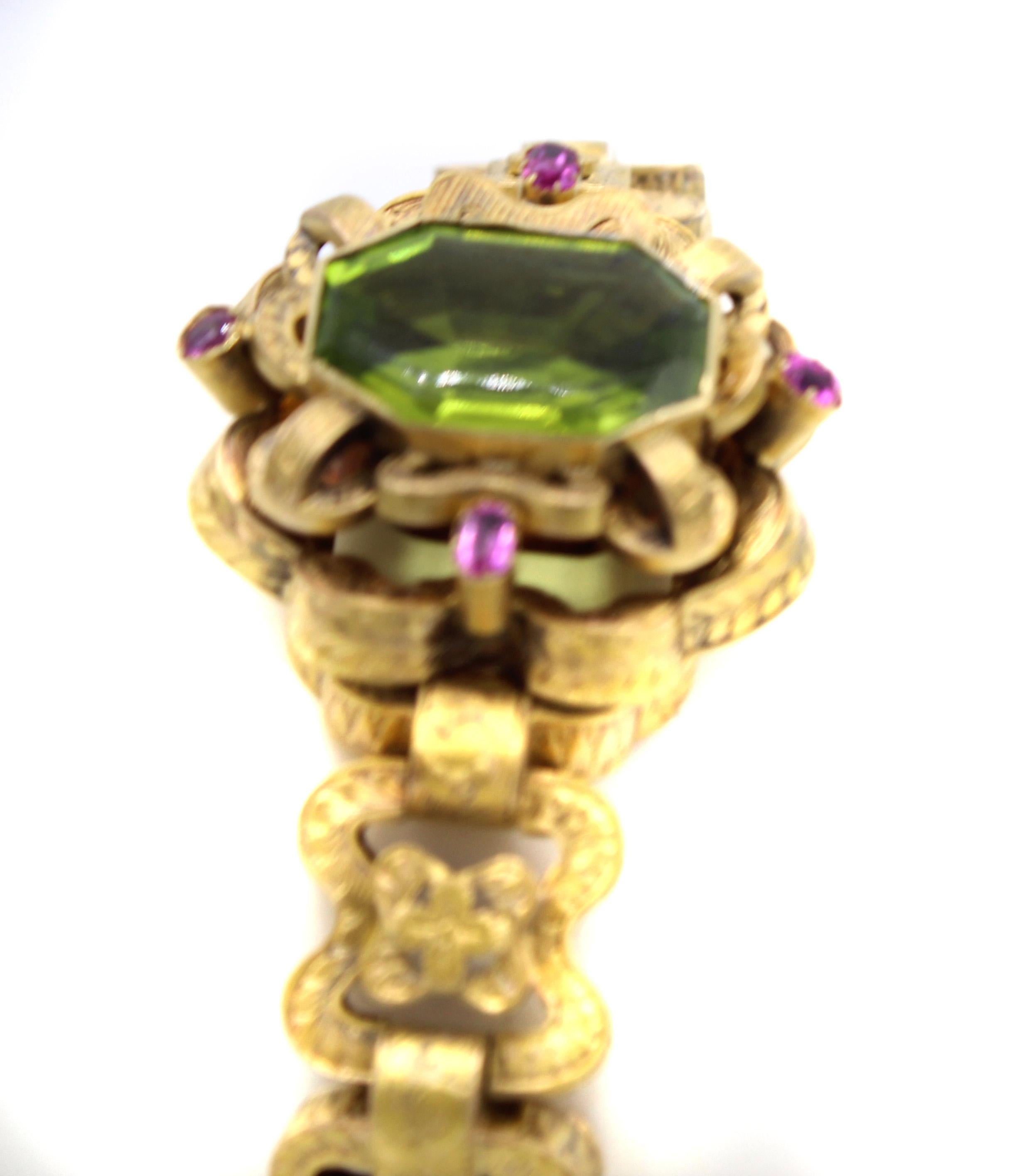 Beautifully designed and masterfully handcrafted this early Victorian link bracelet features wonderful olive green octagonal step-cut Peridot. The Peridot is set within a bezel of gold on top of an ornate gallery of bow-like elements which are