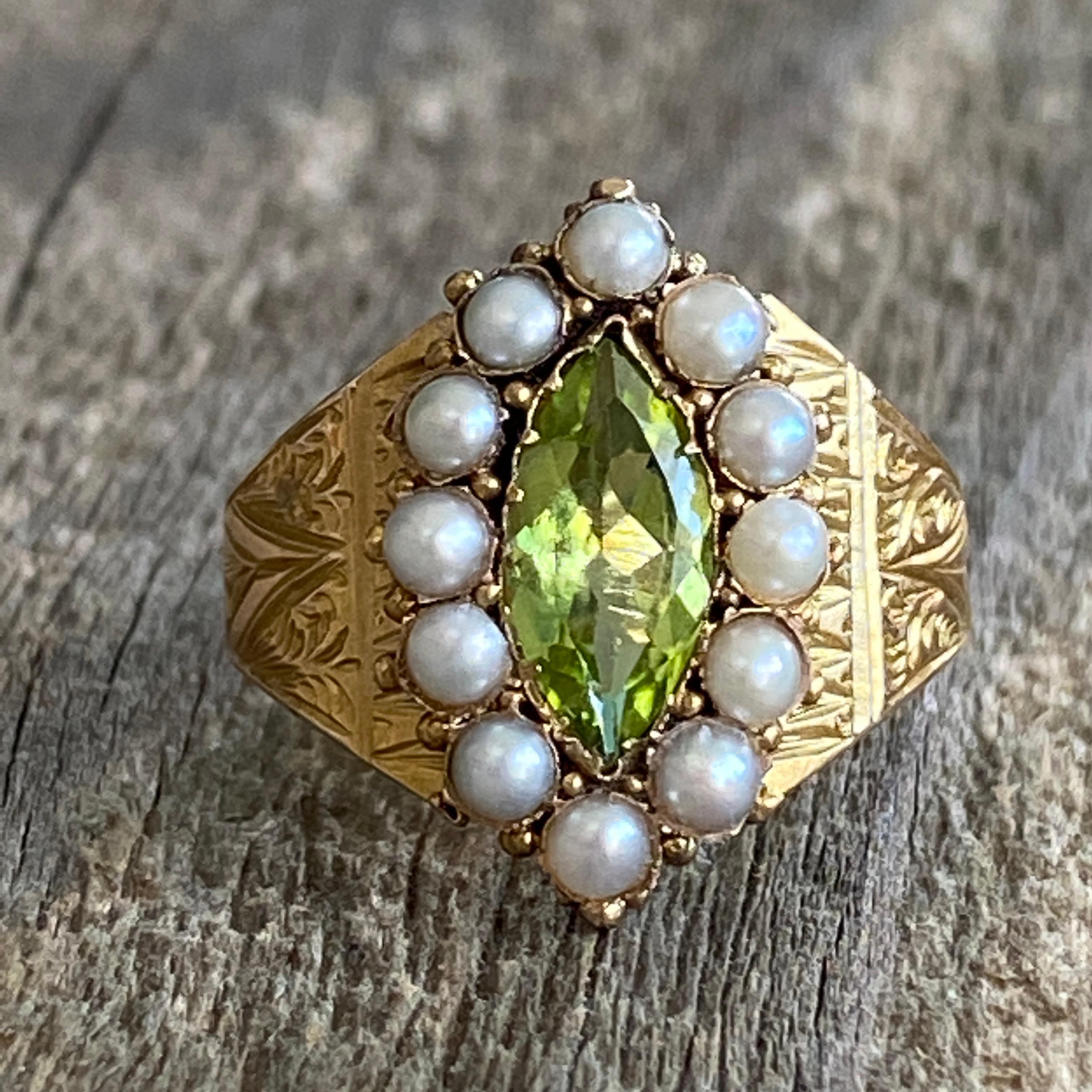 Details:
Absolutely stunning Victorian piece! This is a beautiful green marquise peridot, surrounded by seed pearls set in a stunning yellow 15K yellow gold, engraved around the entire ring. The marquise cut peridot measures 11mm x 6mm, and is