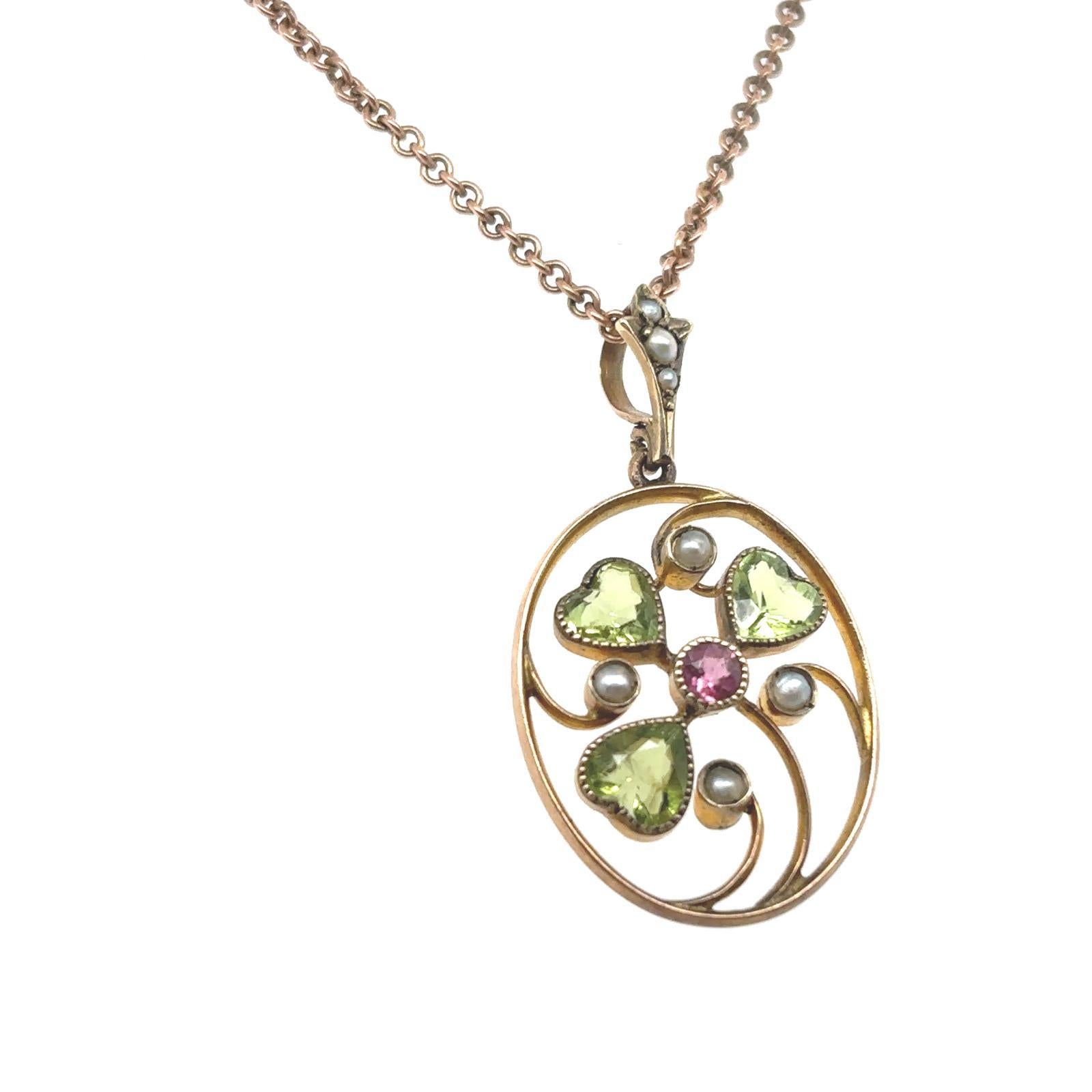 A Victorian peridot seed pearl and pink sapphire floral 9 karat yellow gold necklace

Designed as a flower, set to its centre with a round cut pink sapphire and surrounded by three heart shaped peridot petals, interspaced with delicately set seed